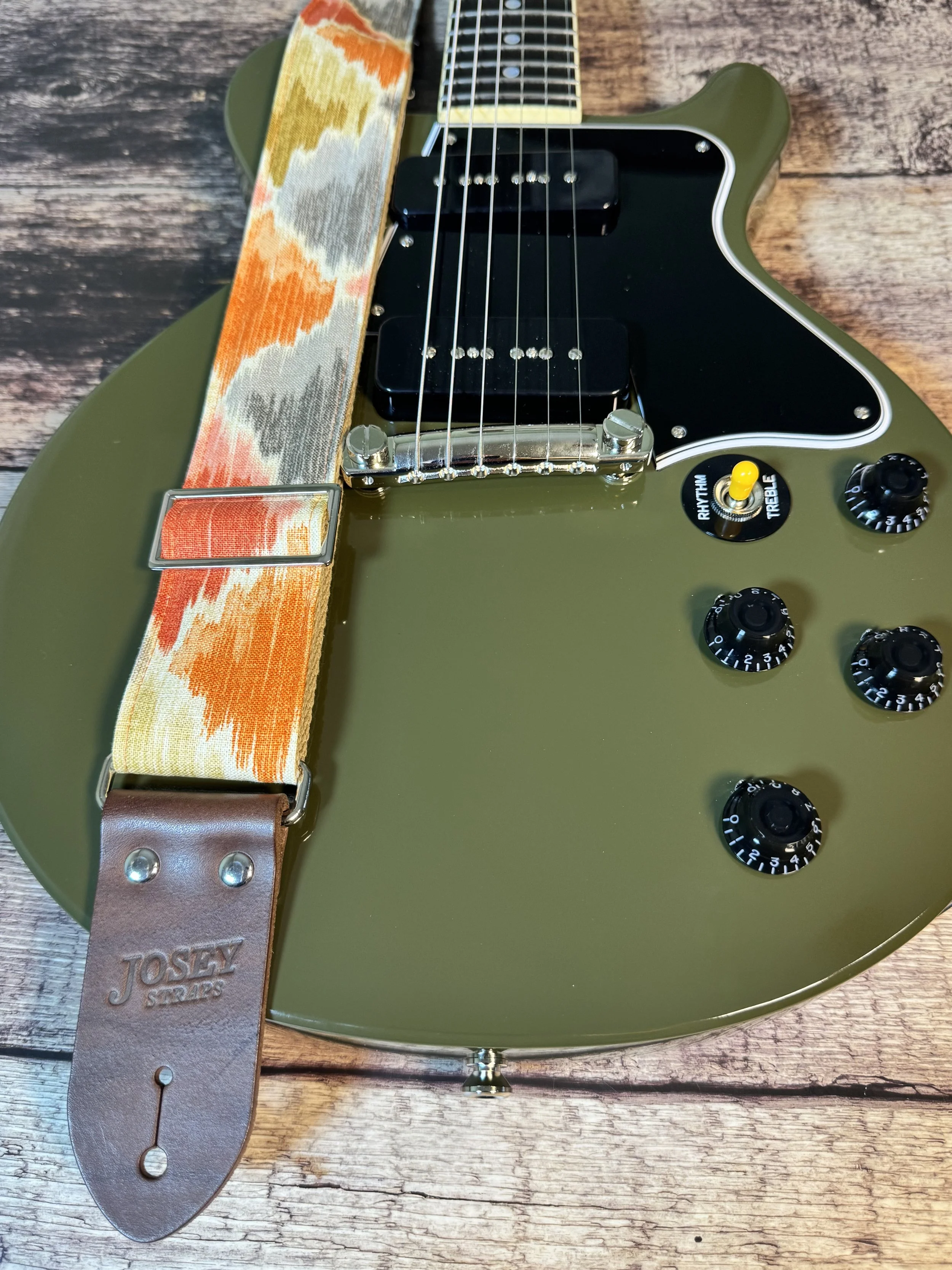 Southwestern themed guitar strap on olive drab guitar.