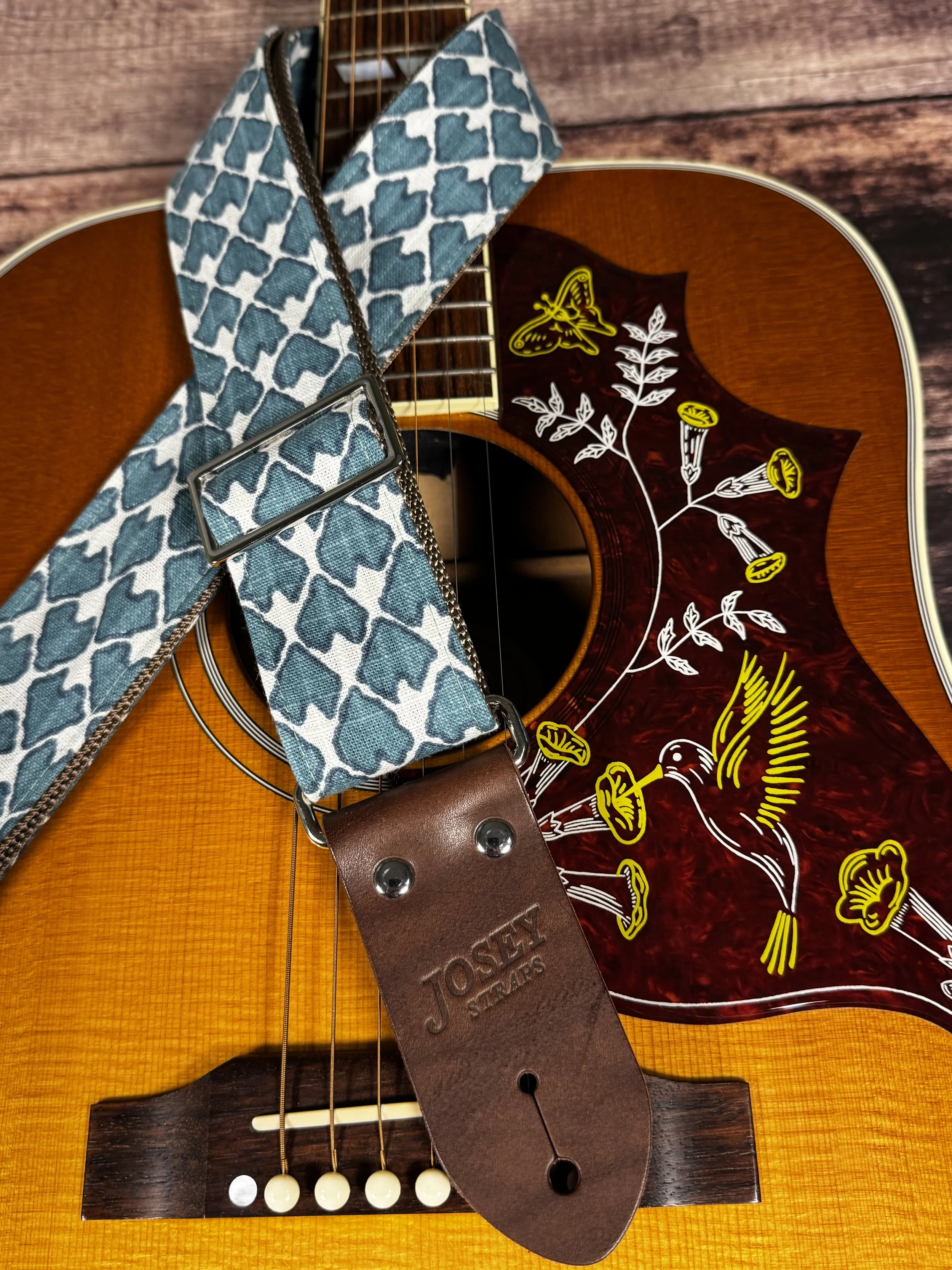Wildwood guitar strap by Josey Straps featuring a teal geometric pattern set on an off-white background.  Finished with premium leather ends.
