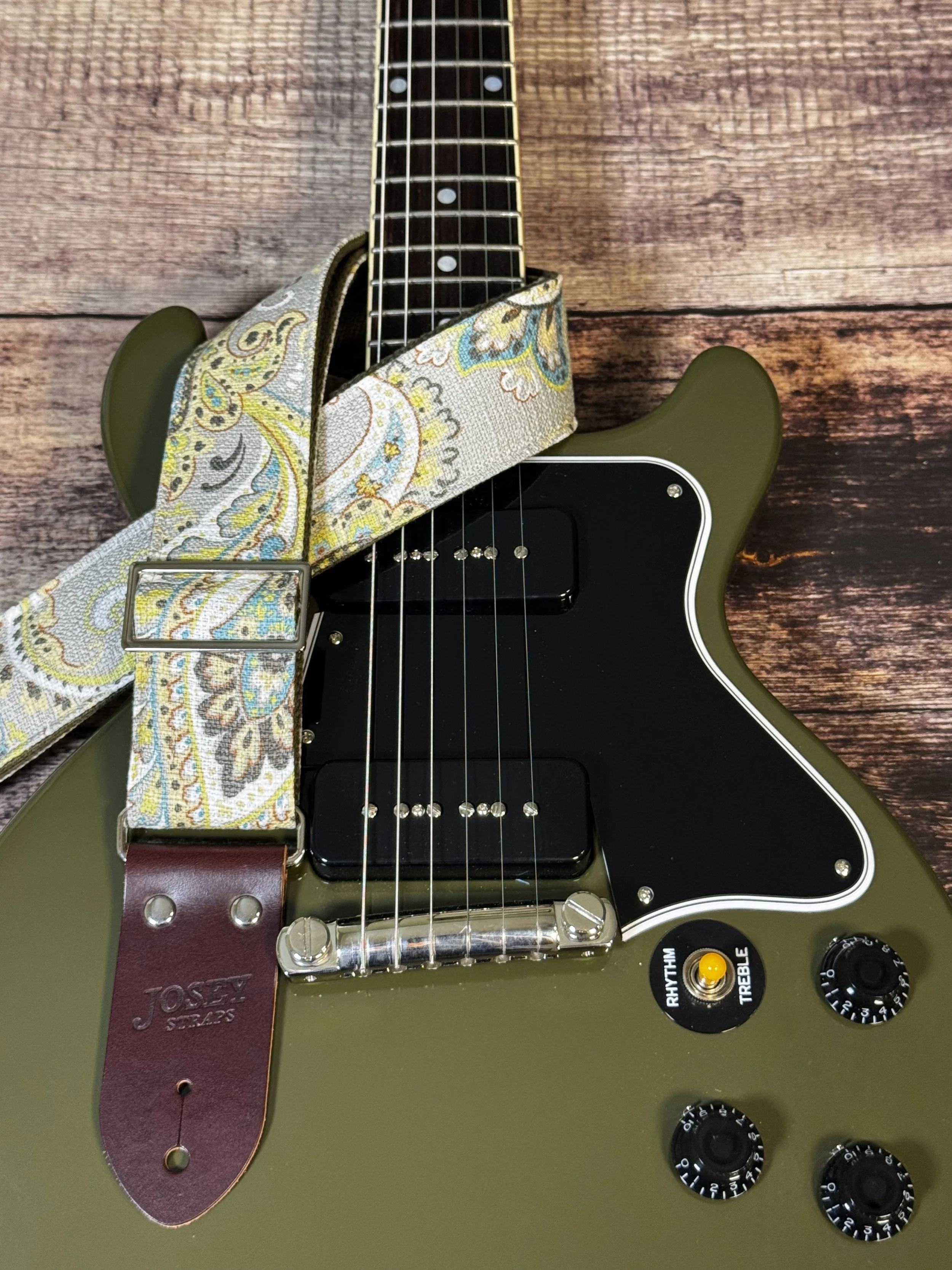 Graisley handmade paisley guitar strap featuring a gray, cream, blue, and mustard vintage-inspired pattern with premium leather ends.