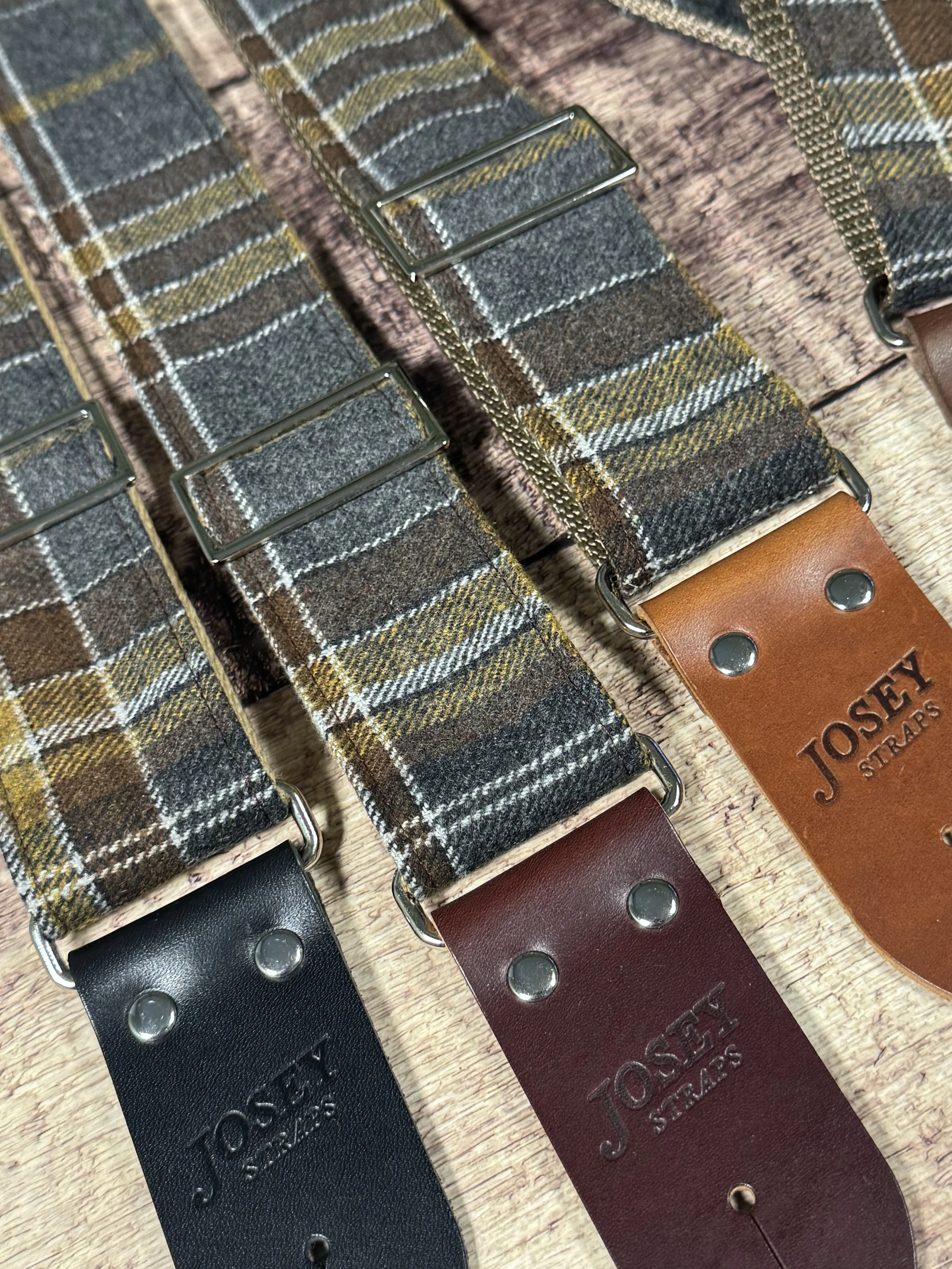 Ashes plaid guitar strap with leather ends by Josey Straps displayed on wood background