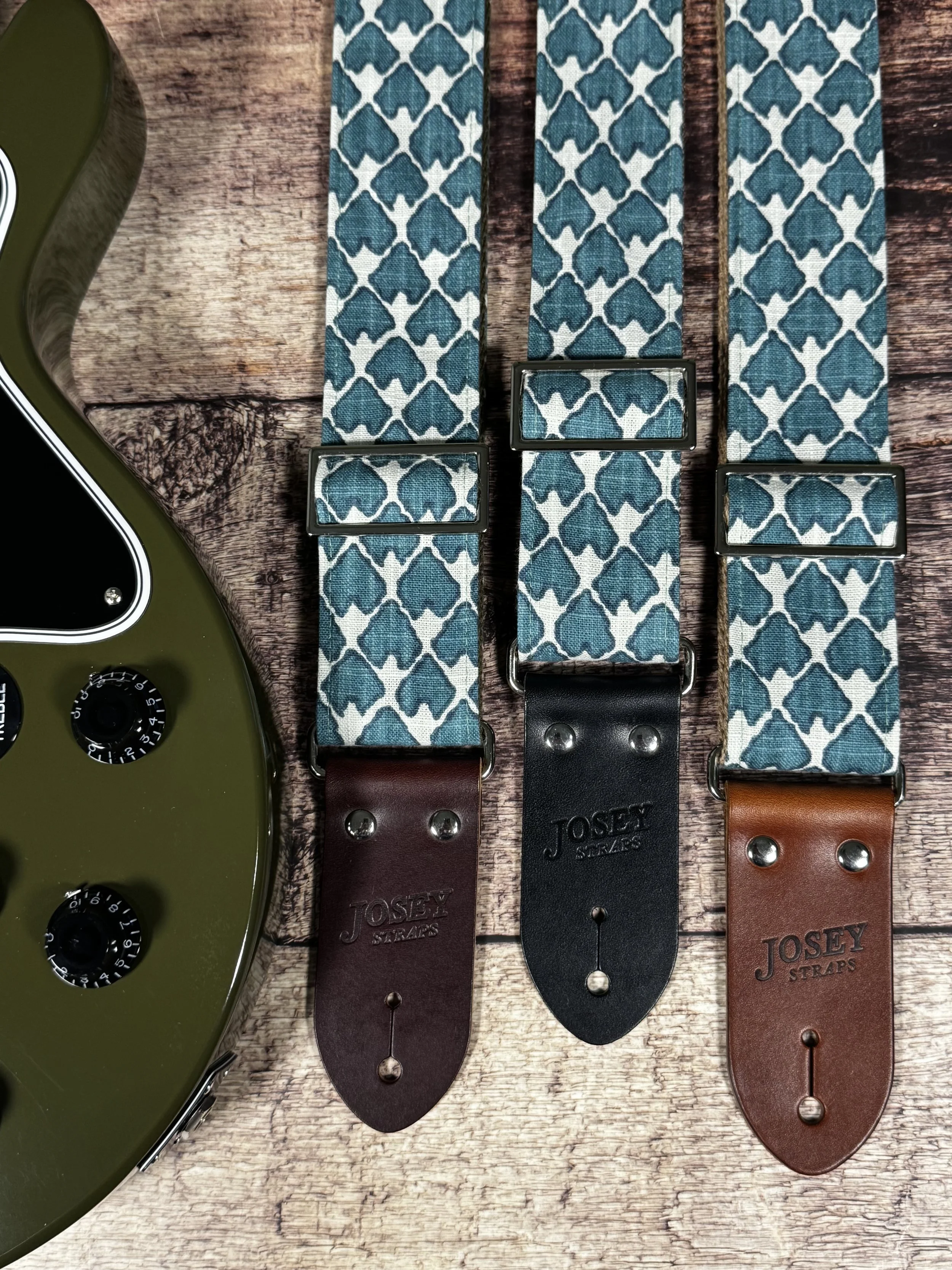 Wildwood guitar strap by Josey Straps featuring a teal geometric pattern set on an off-white background.  Finished with premium leather ends.