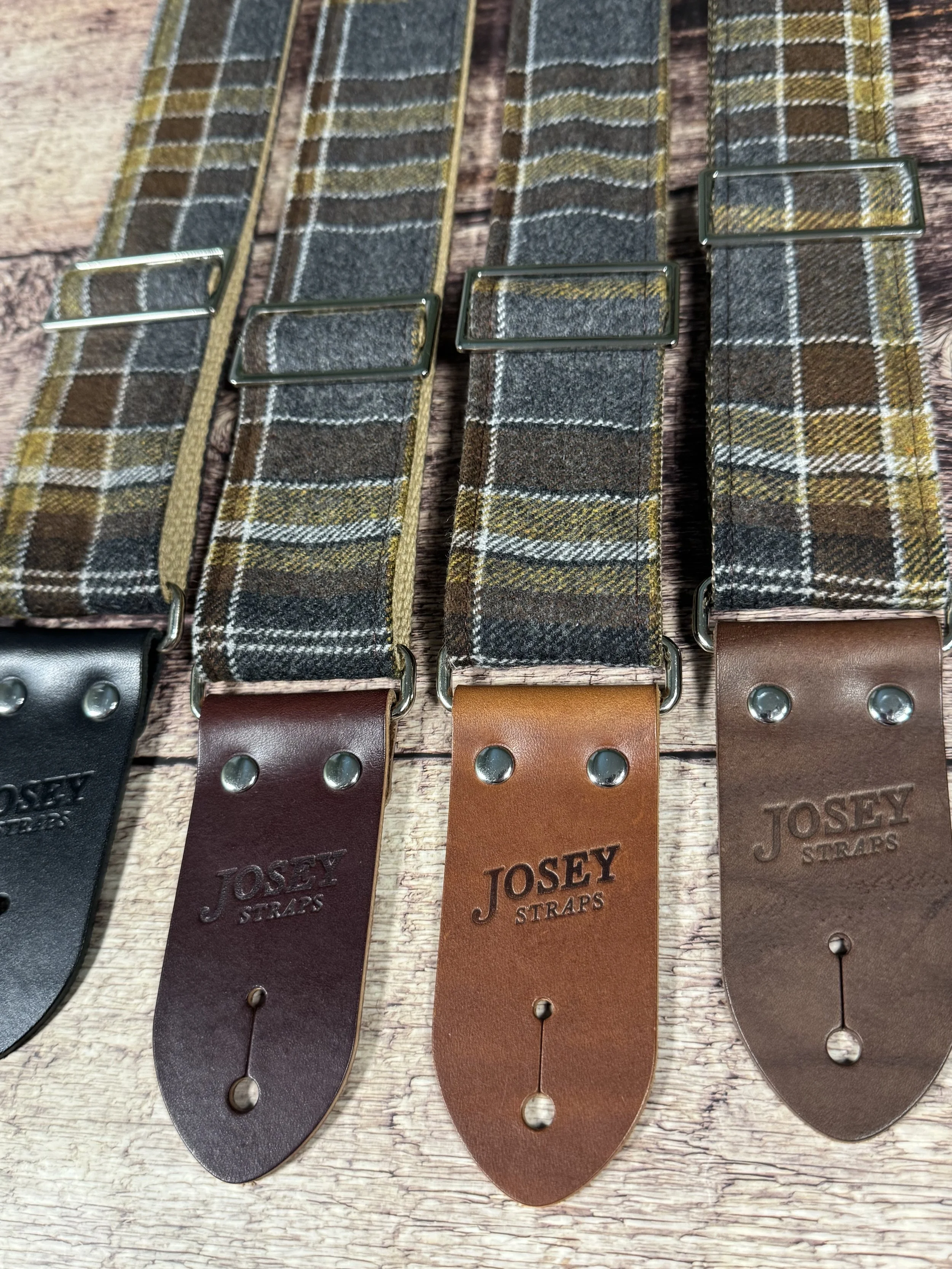 Ashes plaid guitar strap with leather ends by Josey Straps displayed on wood background