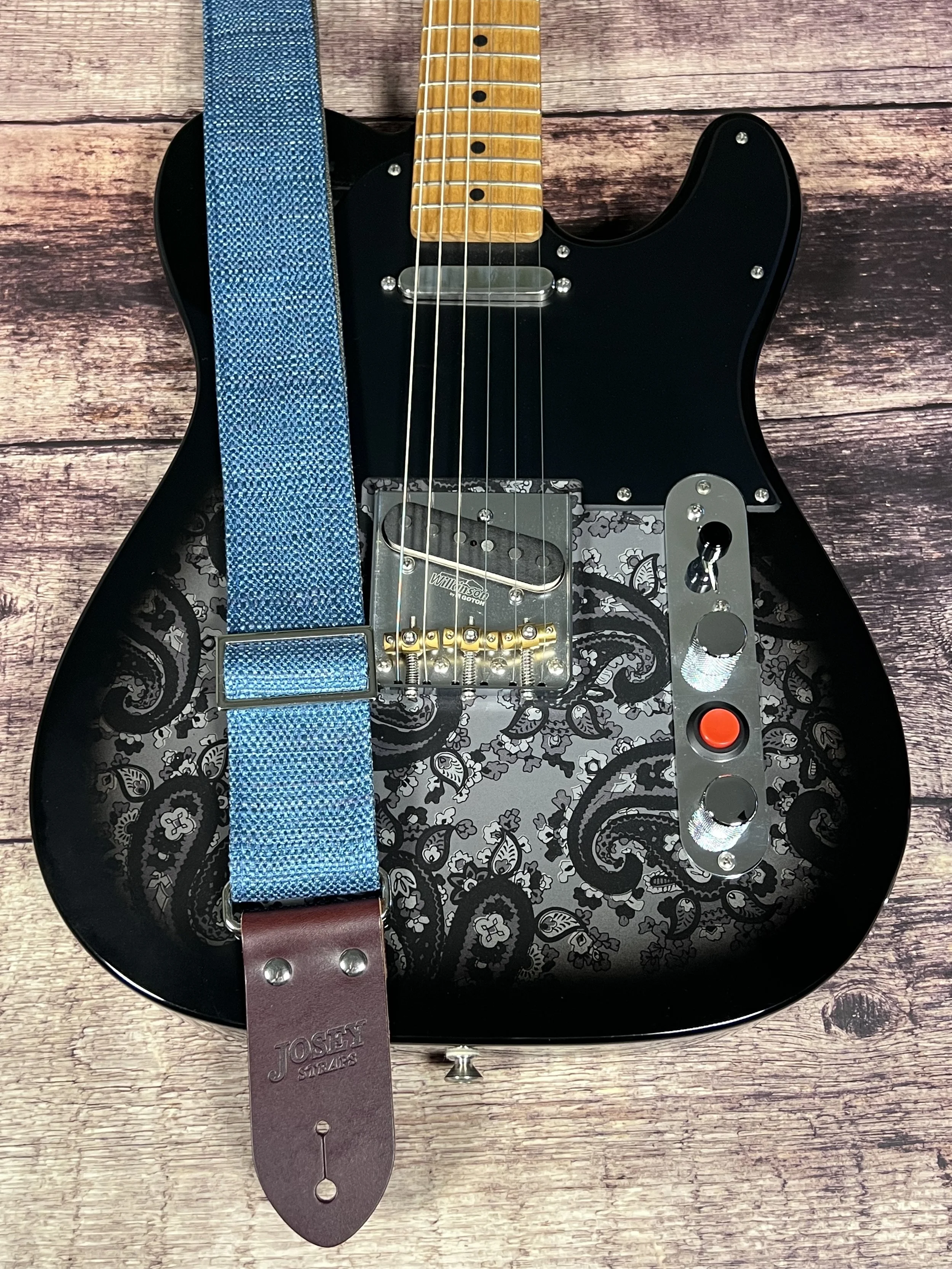 Peacock Blue woven guitar strap with blue-green texture and leather ends by Josey Straps on a black paisley guitar.