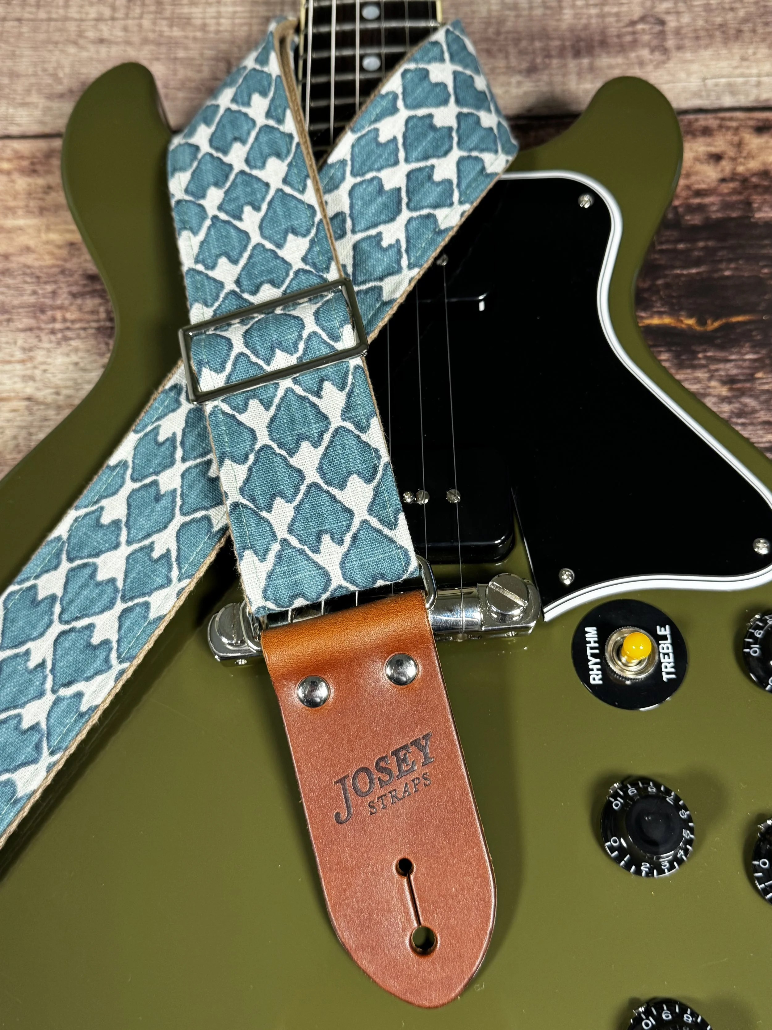 Wildwood guitar strap by Josey Straps featuring a teal geometric pattern set on an off-white background.  Finished with premium leather ends.