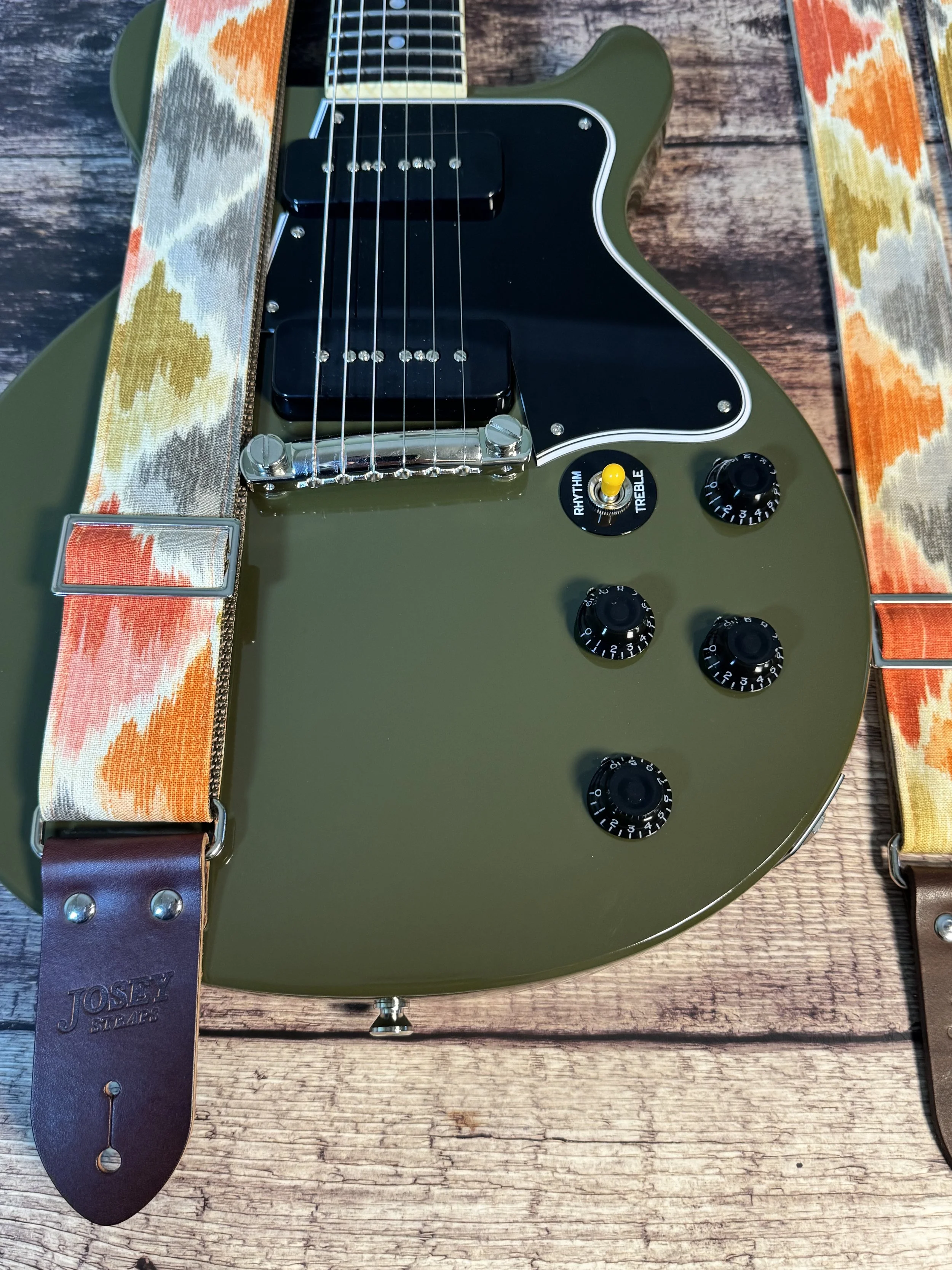 Southwestern themed guitar strap on olive drab guitar.