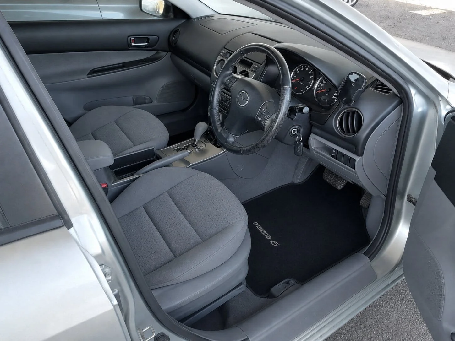 Freshly cleaned car interior after mould removal, with restored seats, clean floor mats, wiped dashboard, steering wheel and centre console.