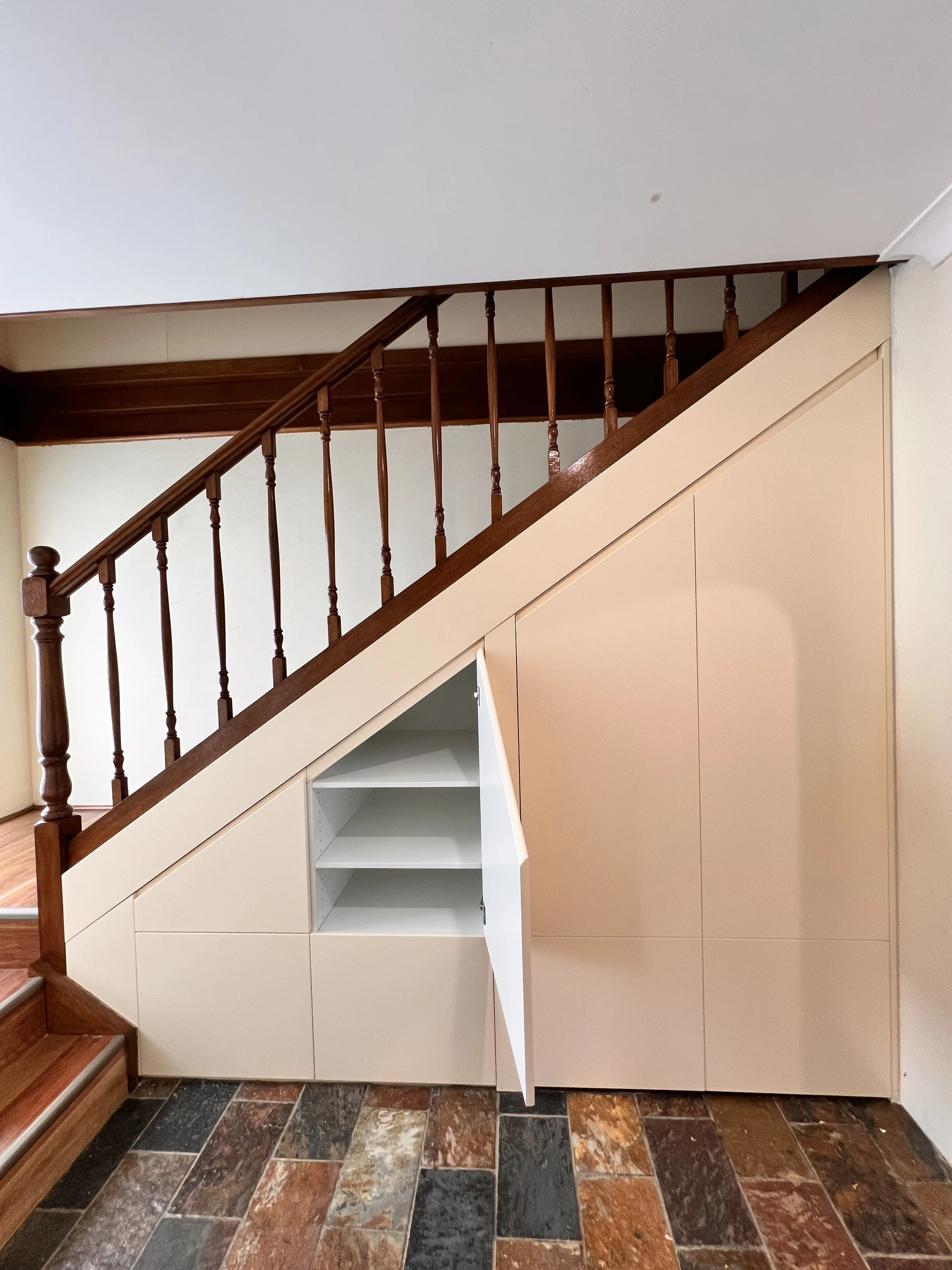 Modern under stairs storage solution with satin polyurethane cabinetry
