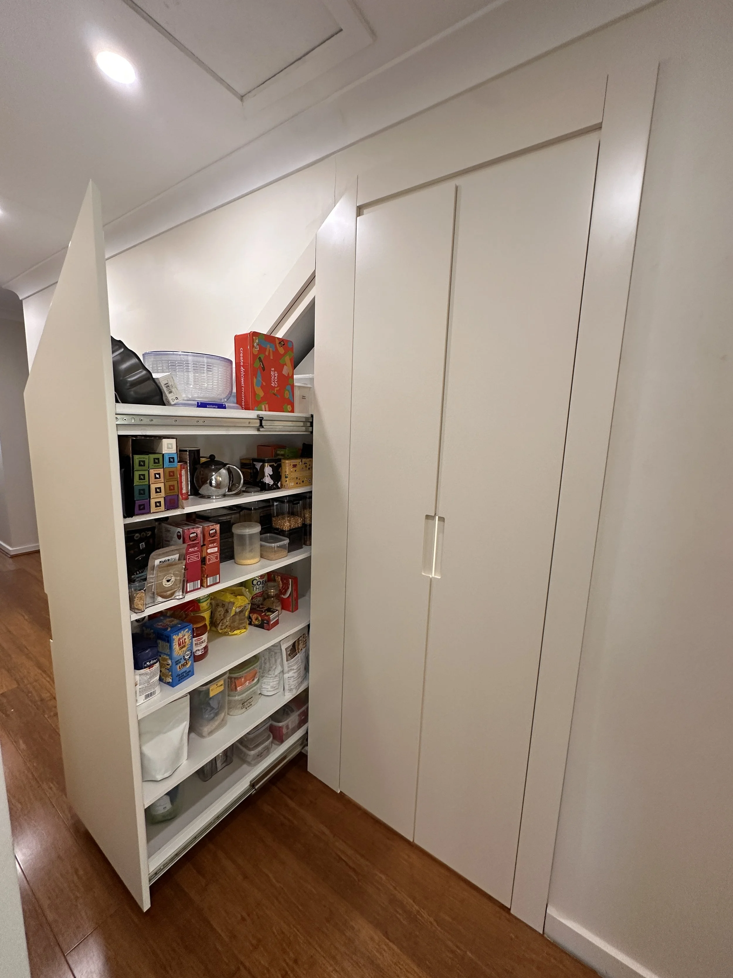 Full under stairs storage solution with drawers, shelving, and panel doors