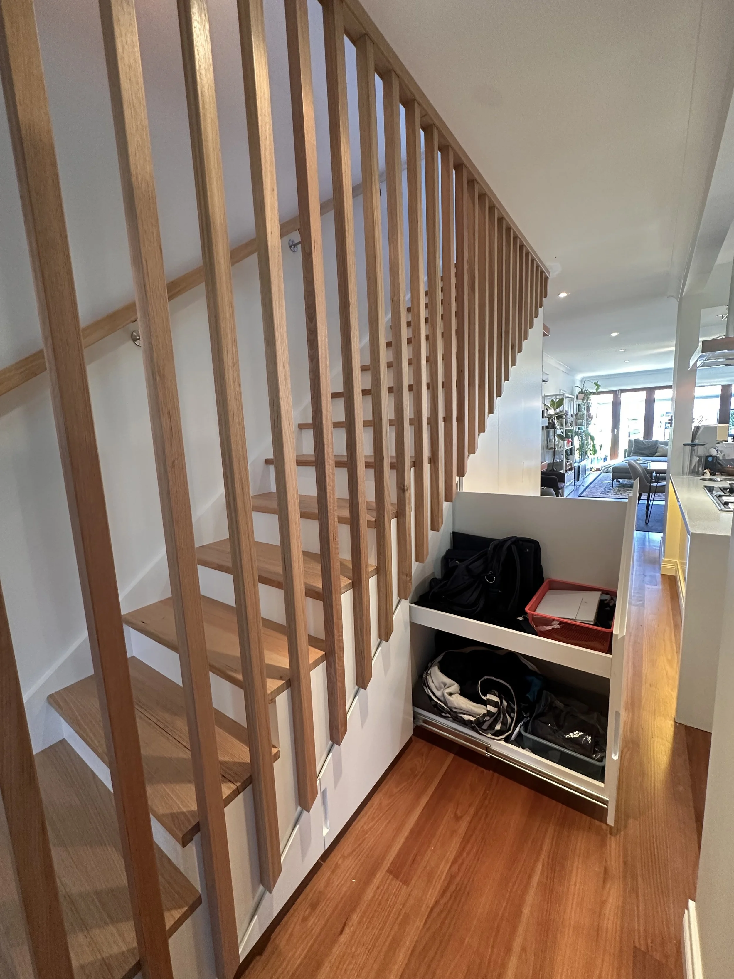 Built-in storage solution under staircase with concealed doors