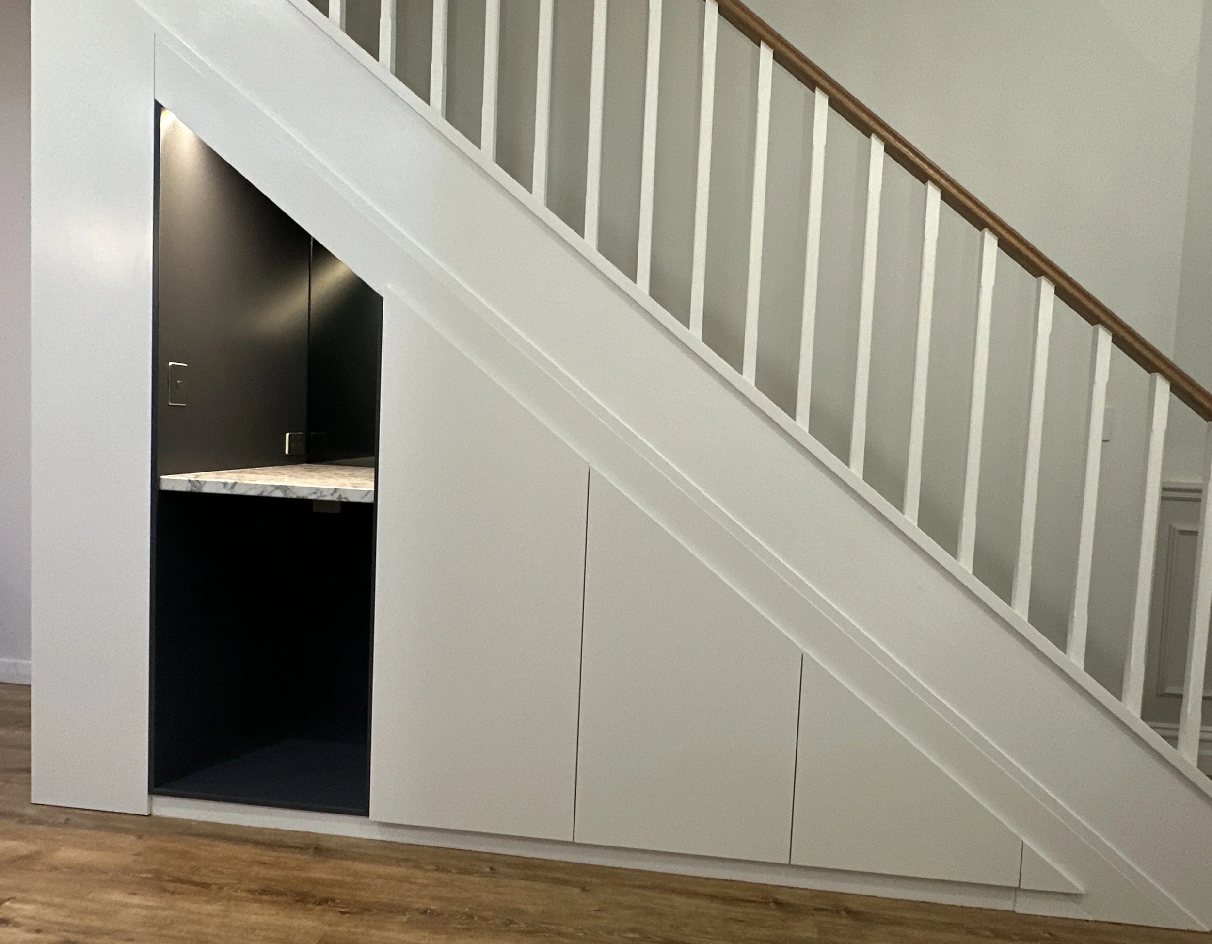 After view of modern cabinetry built seamlessly under staircase