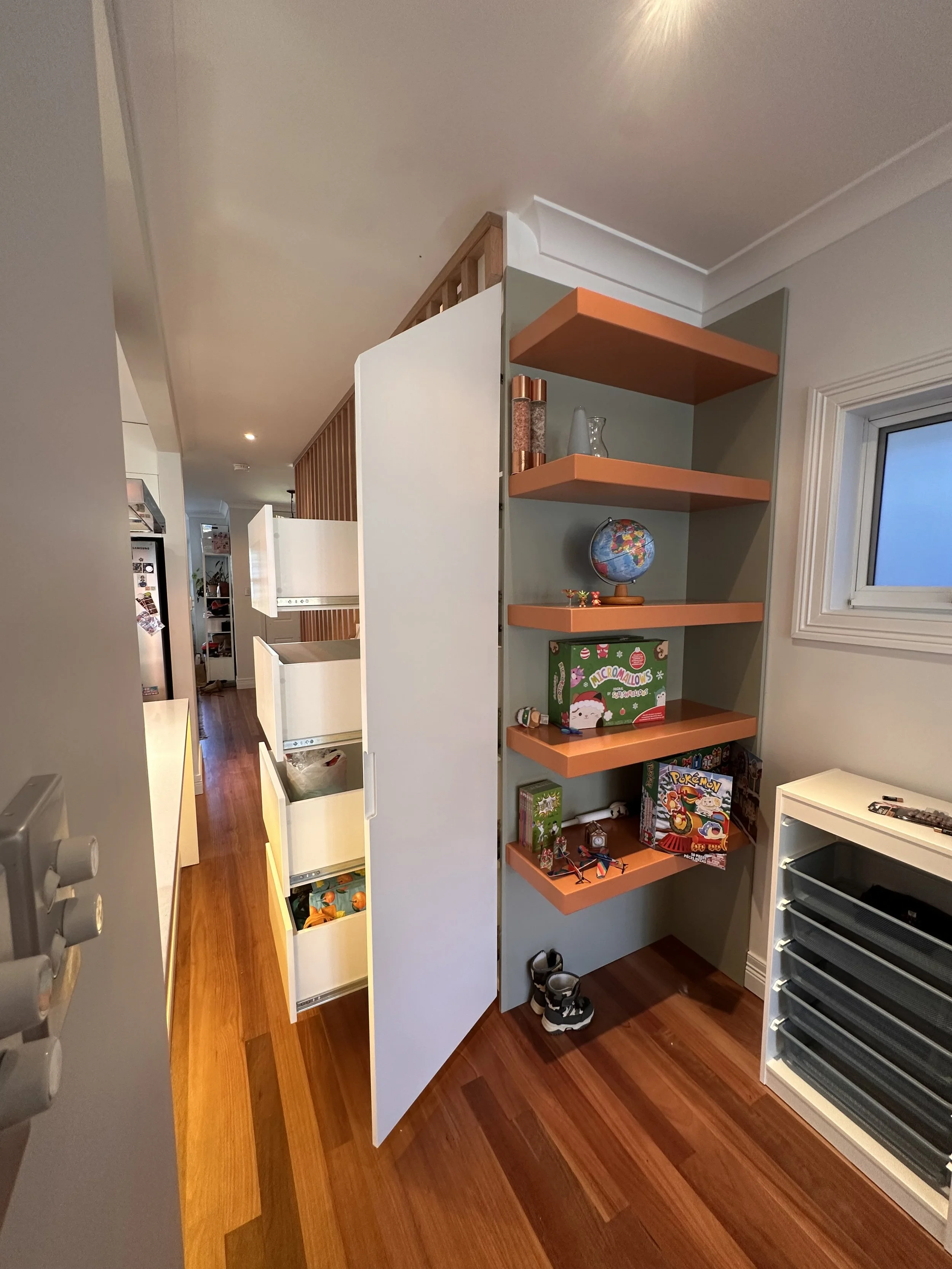 Custom hallway cabinetry fitted under staircase with sleek modern design