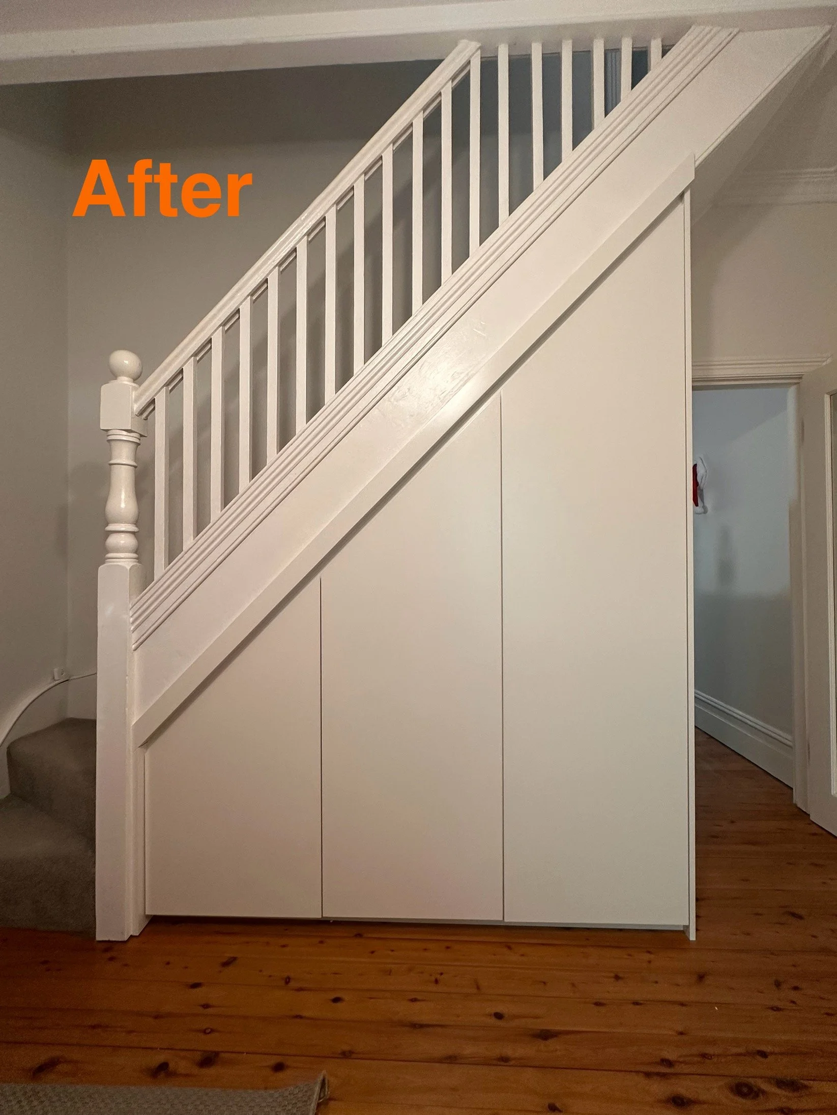 Concealed cabinetry doors under staircase for hidden storage solution