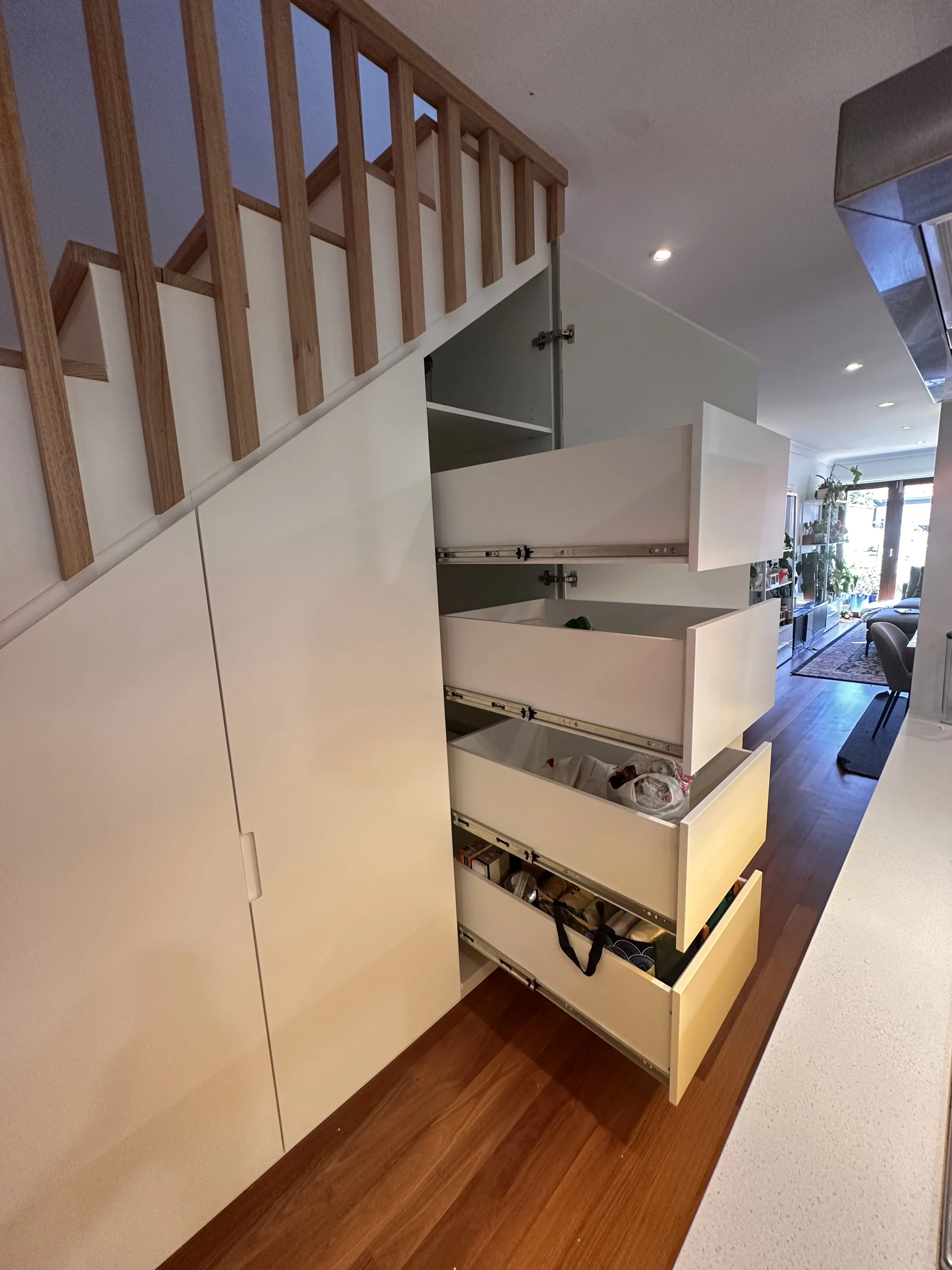 Full under stairs storage solution with drawers, shelving, and panel doors