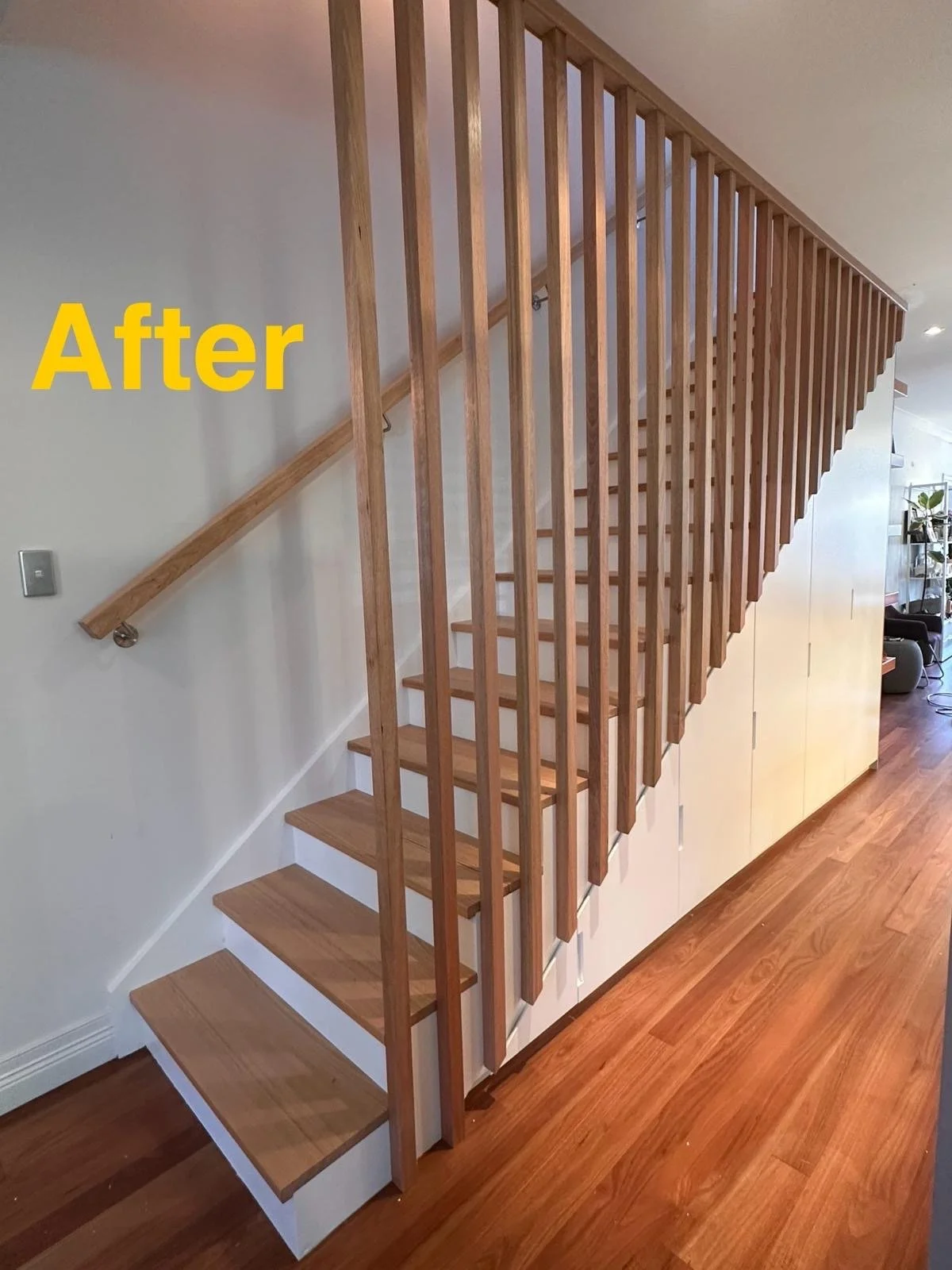 After installation of custom under stairs cabinetry with white polyurethane doors and timber staircase finish