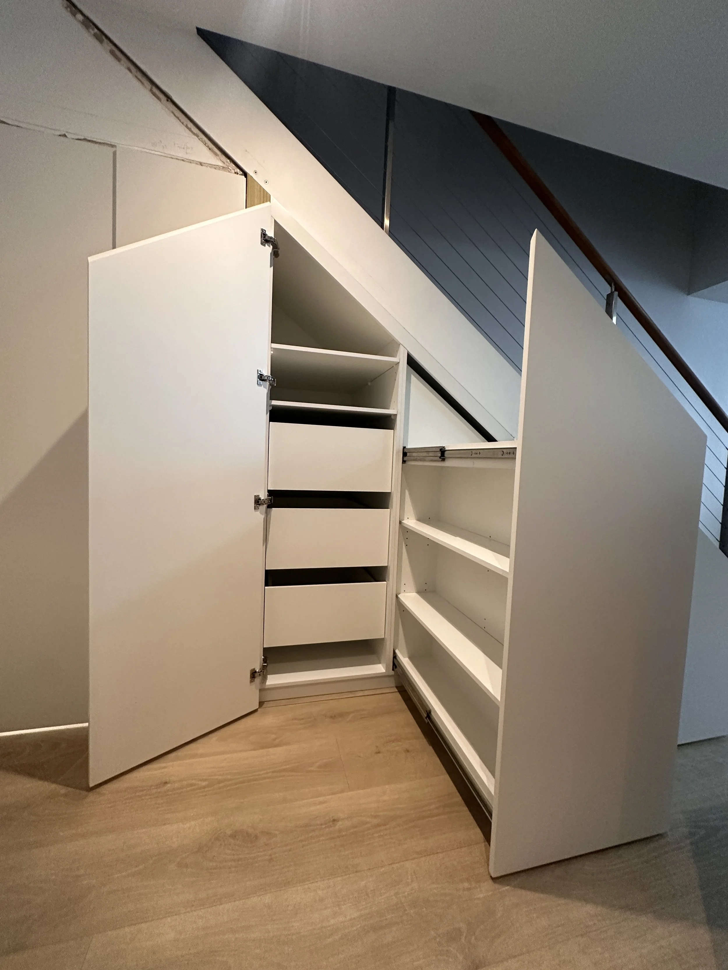 Full under stairs storage solution with drawers, shelving, and panel doors