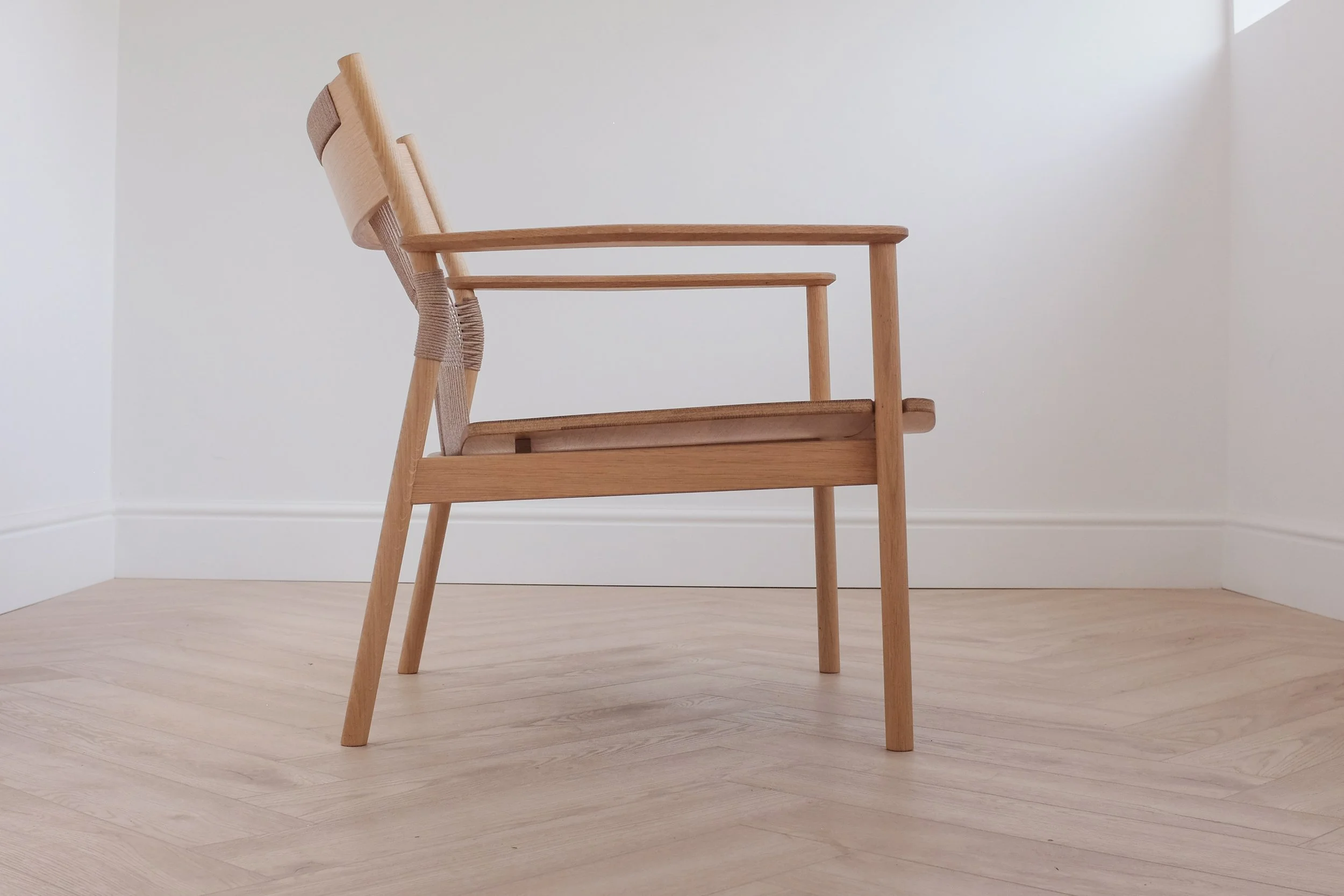 Solid oak easy chair with woven backrest.