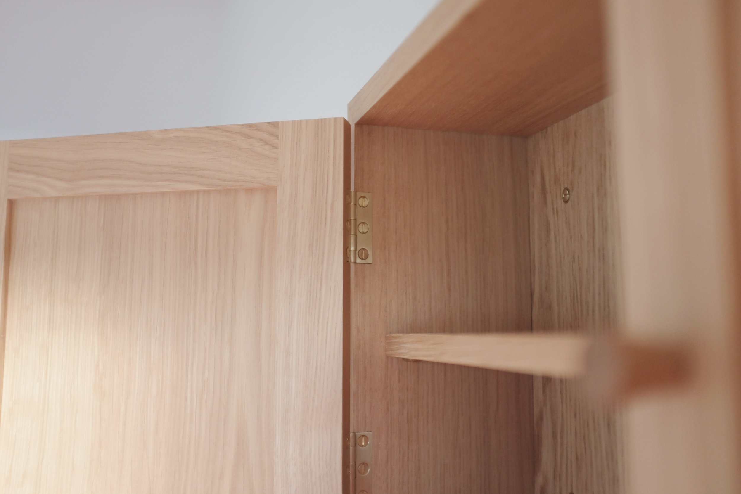 Traditional brass butt hinges on wall mounted cabinet.