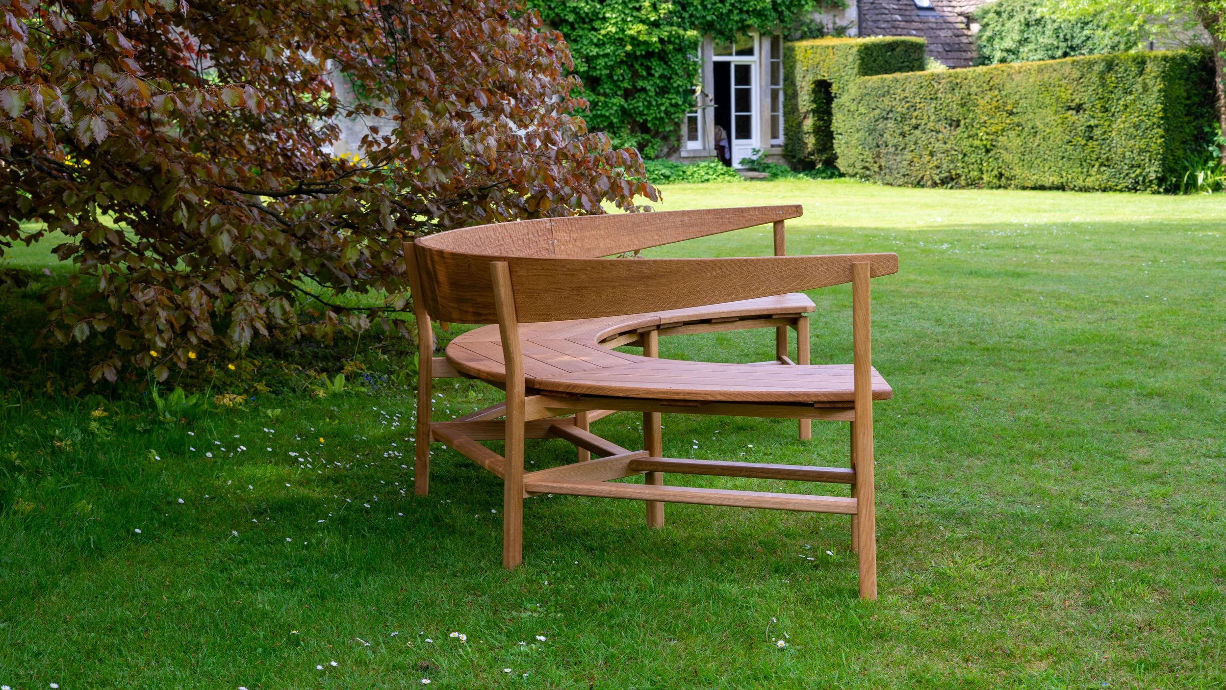 The Coln bench, a large steambent garden bench seat in solid oak.