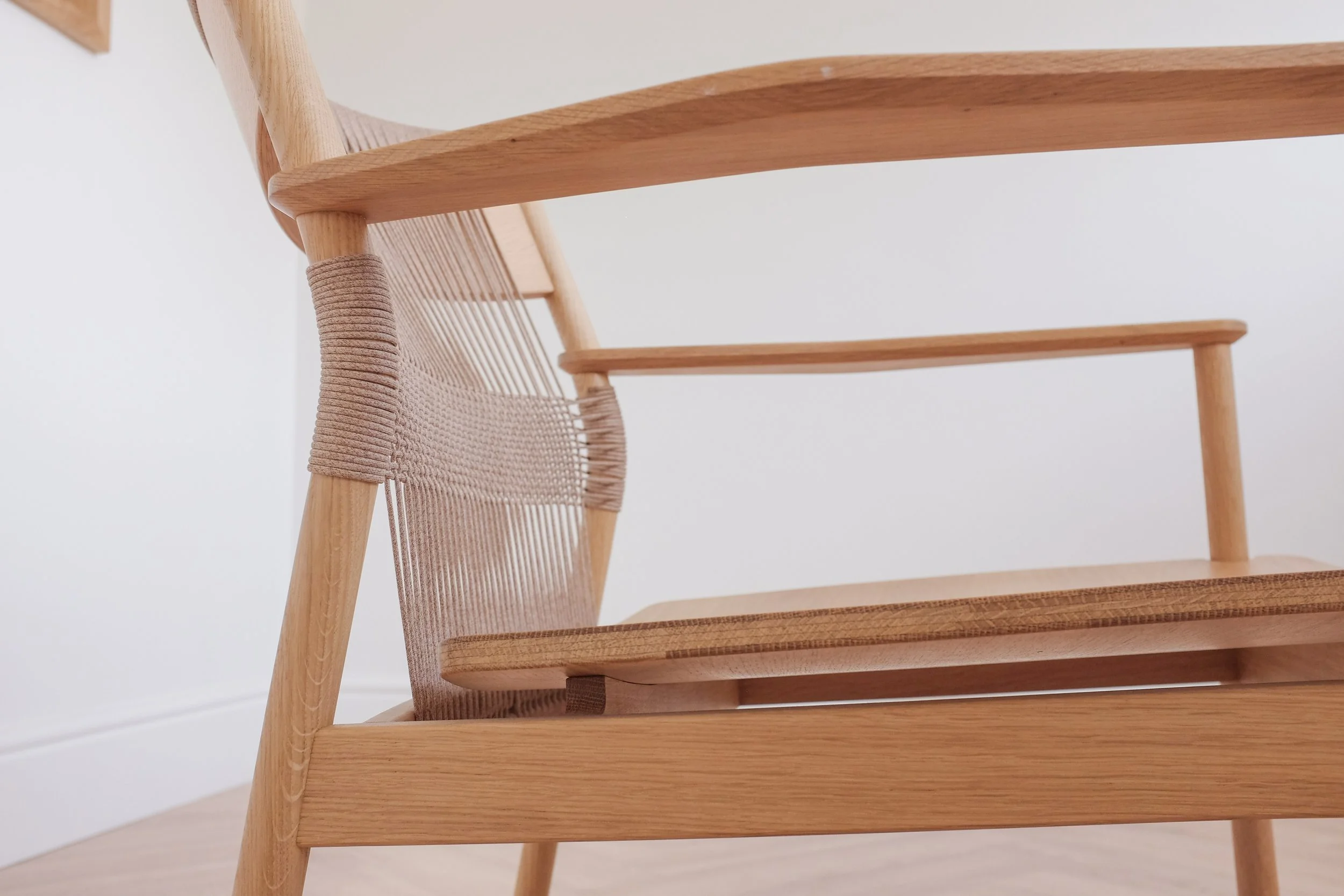 Woven backrest on solid oak easy chair.