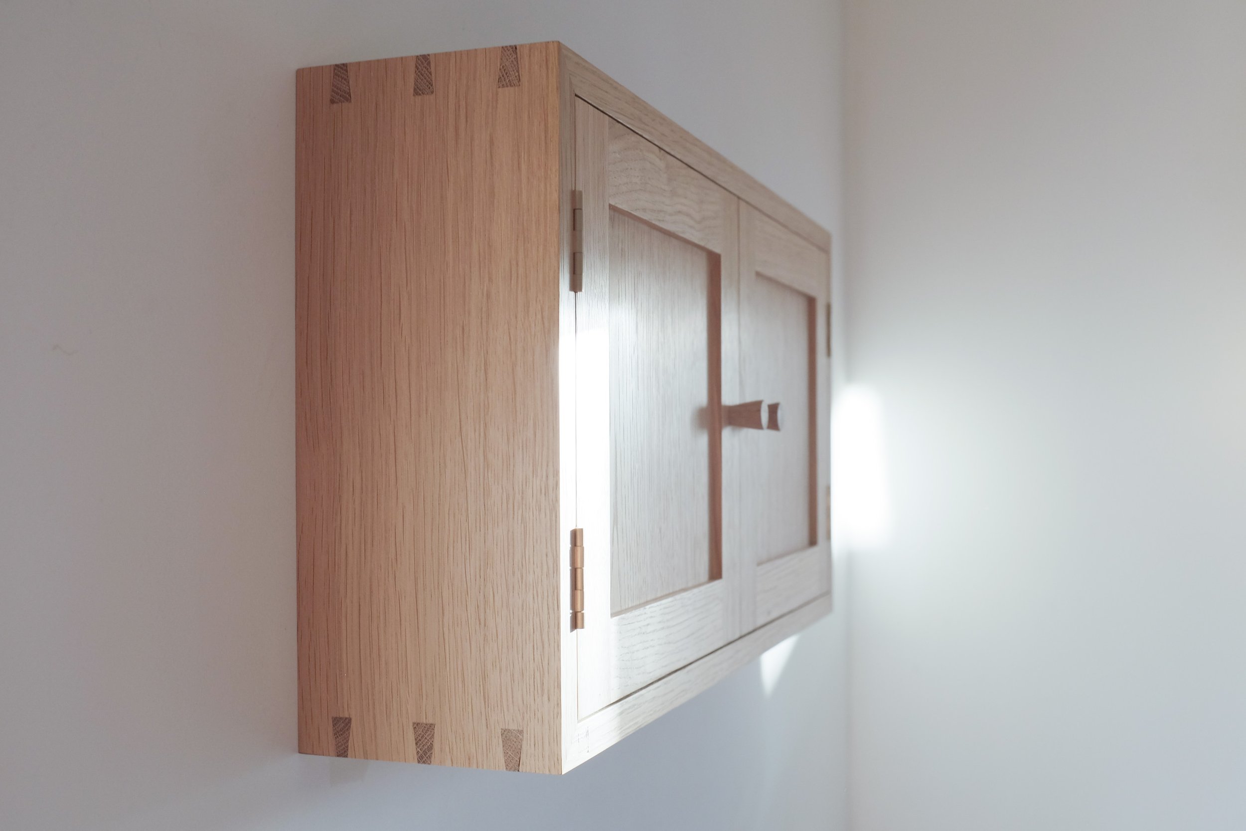 Dovetailed side of solid oak wall cabinet.
