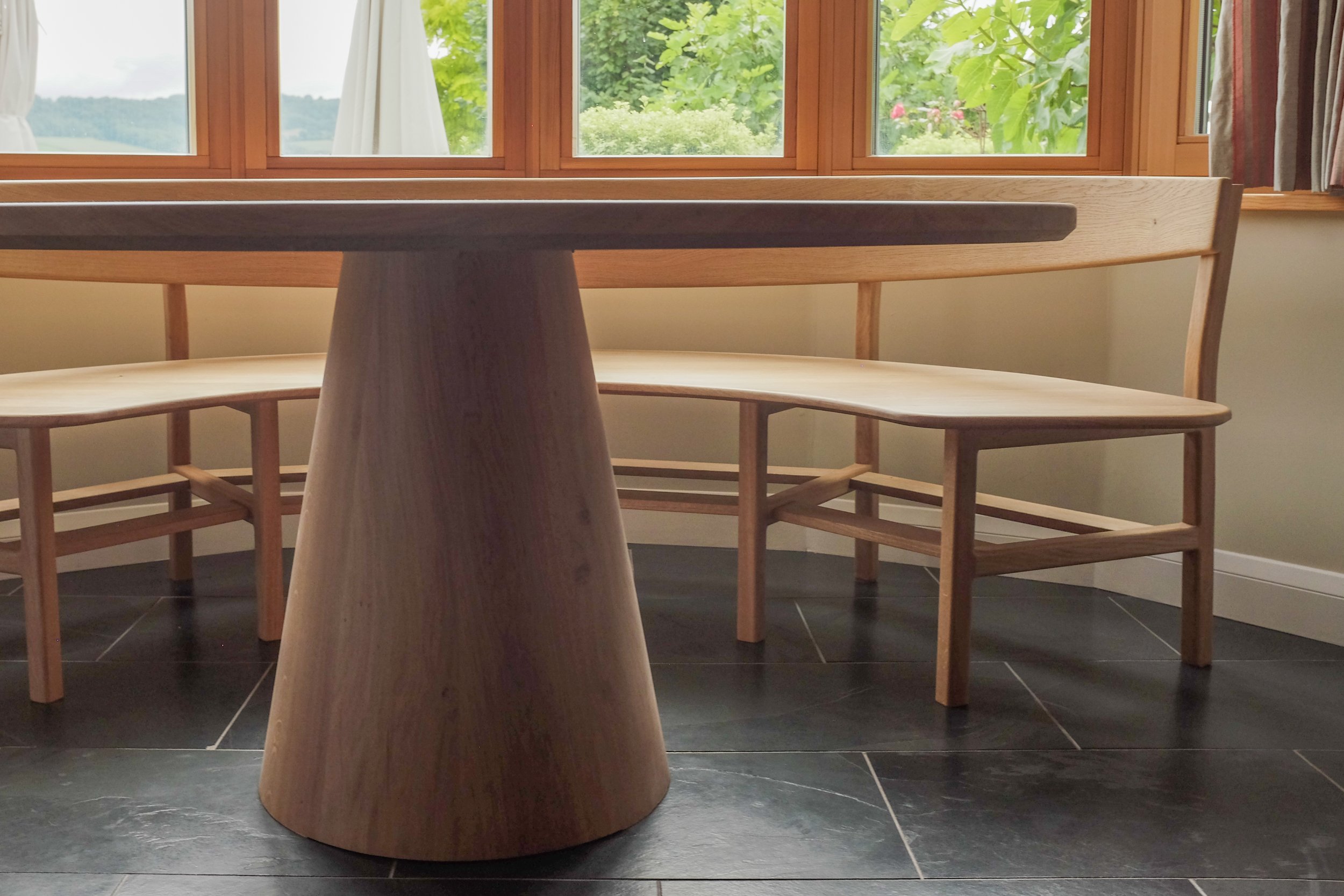 The conical coopered solid oak base of the Wye dining table.