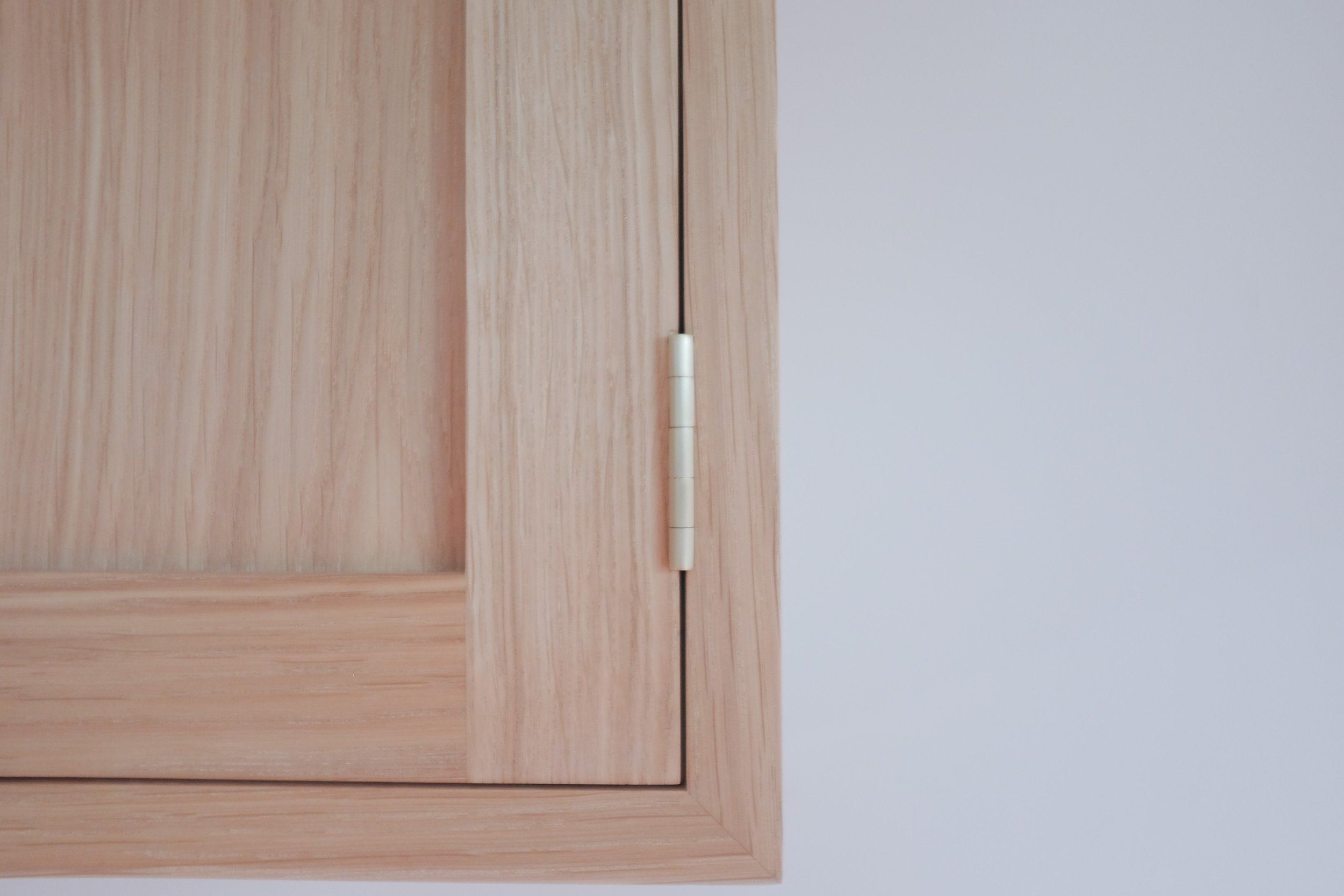 Traditional brass butt hinges on wall mounted cabinet.