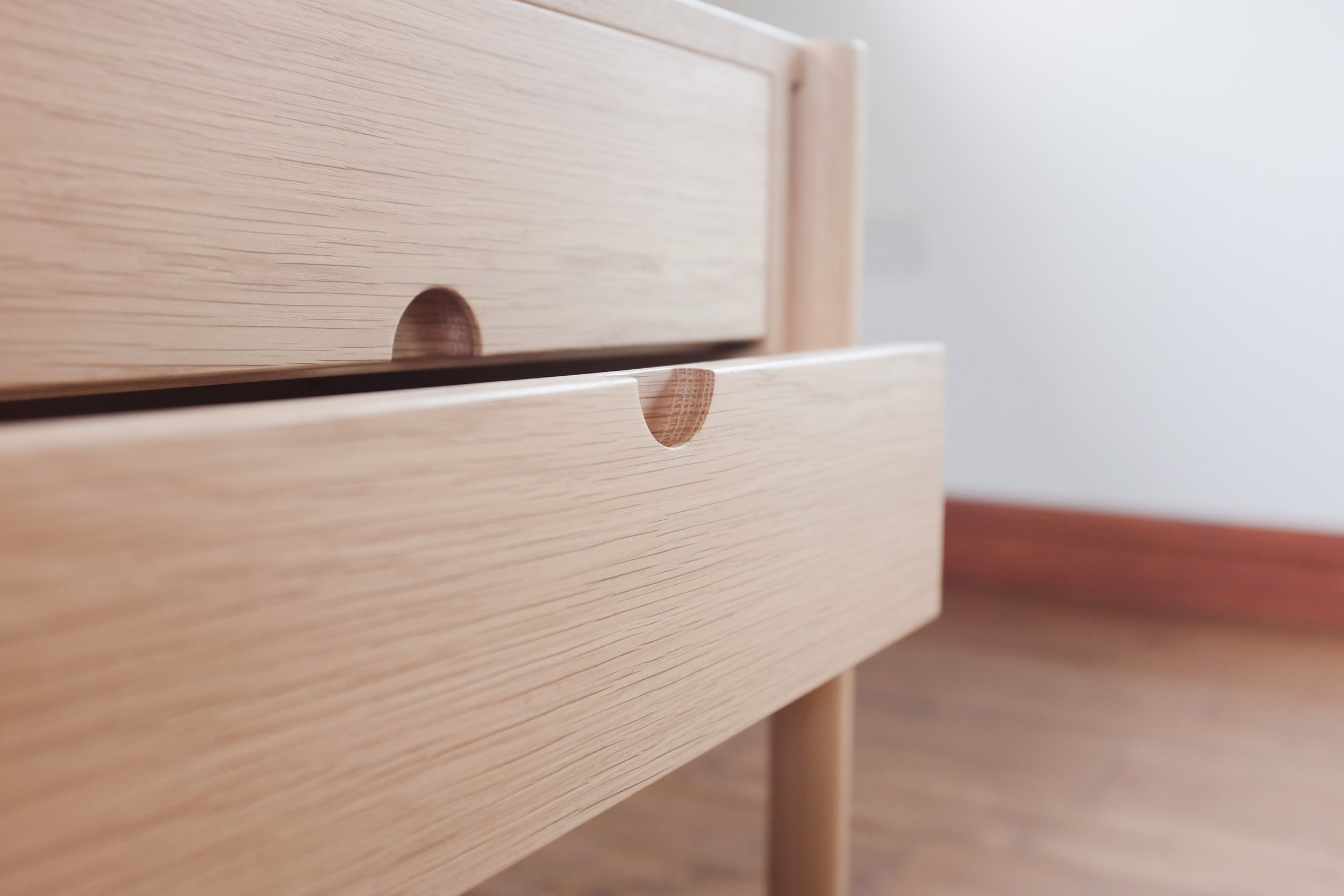 Curved circular handle detail on open drawers.
