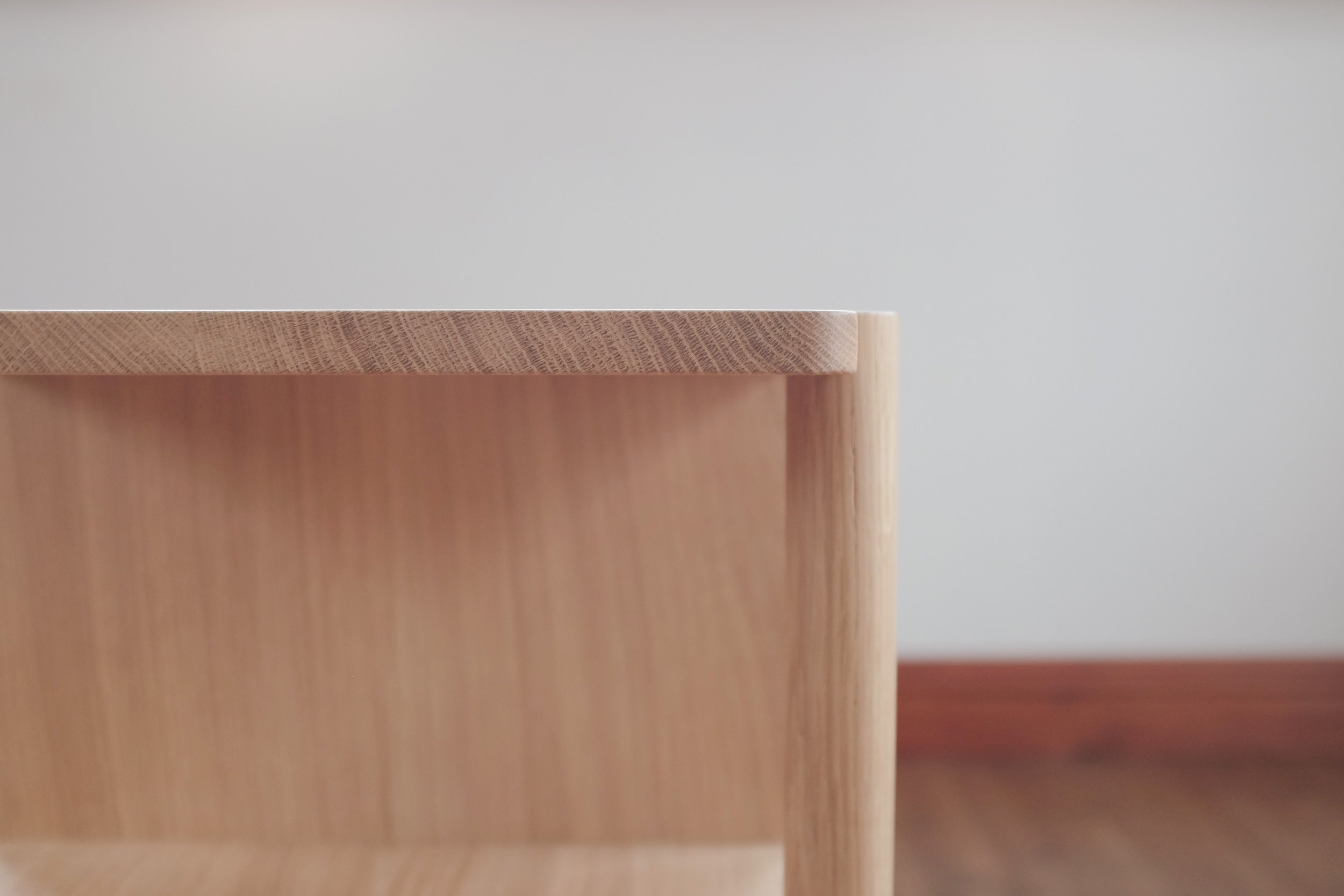 Open shelving on the side of the oak Romal bedside drawers.