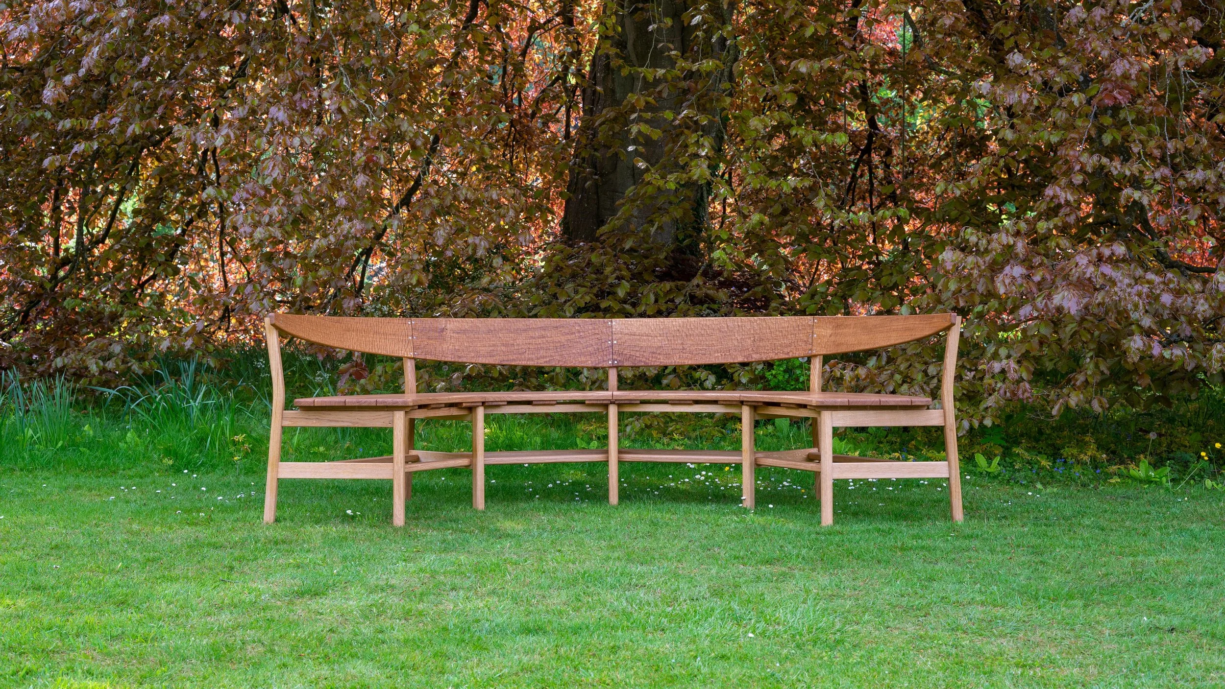 The Coln bench, a large steambent garden bench seat in solid oak.