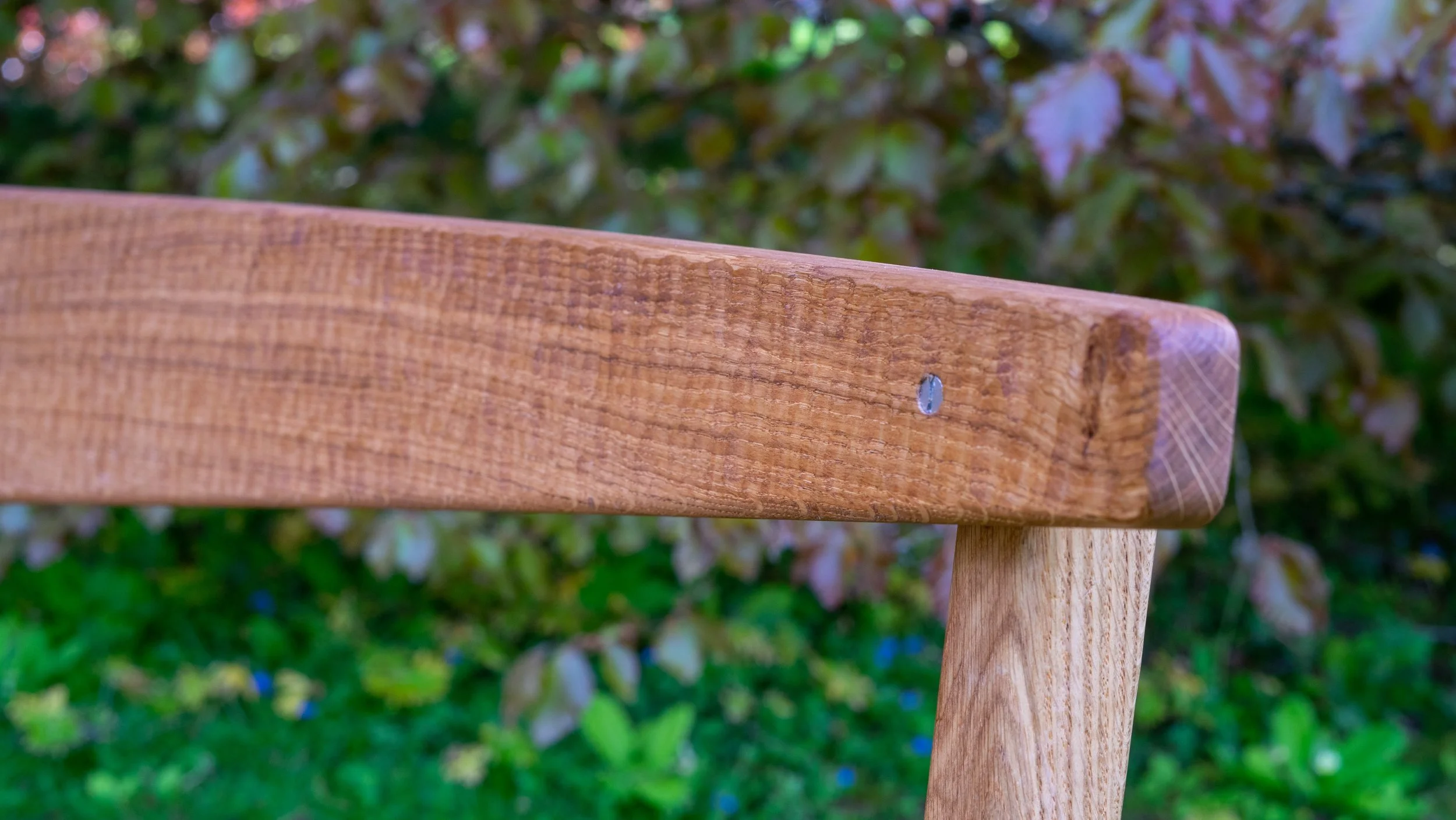 The textured backrest of the solid oak Coln garden bench.