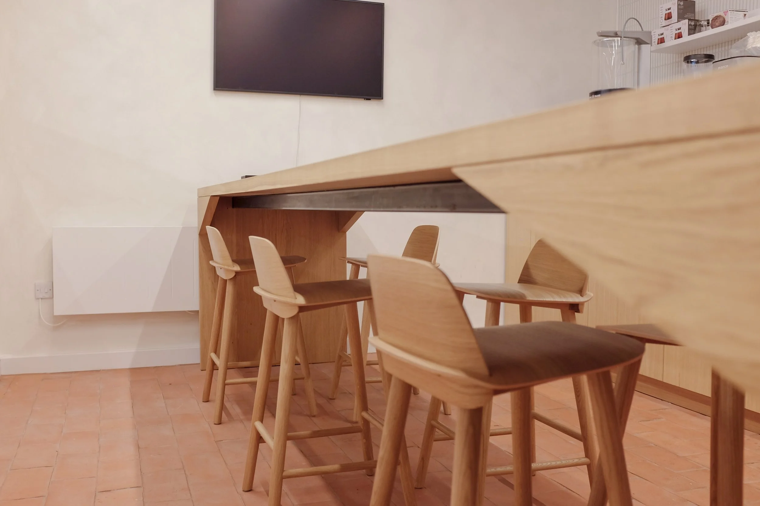 The Origin Bench, four metre long conference table in solid oak with oak stools.