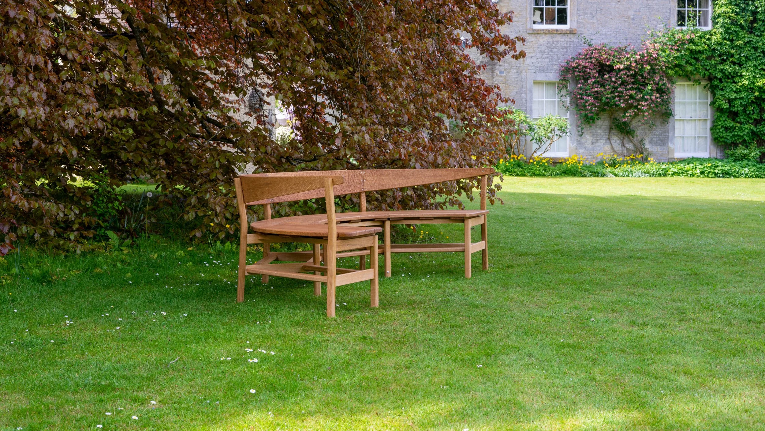 The Coln bench, a large steambent garden bench seat in solid oak.