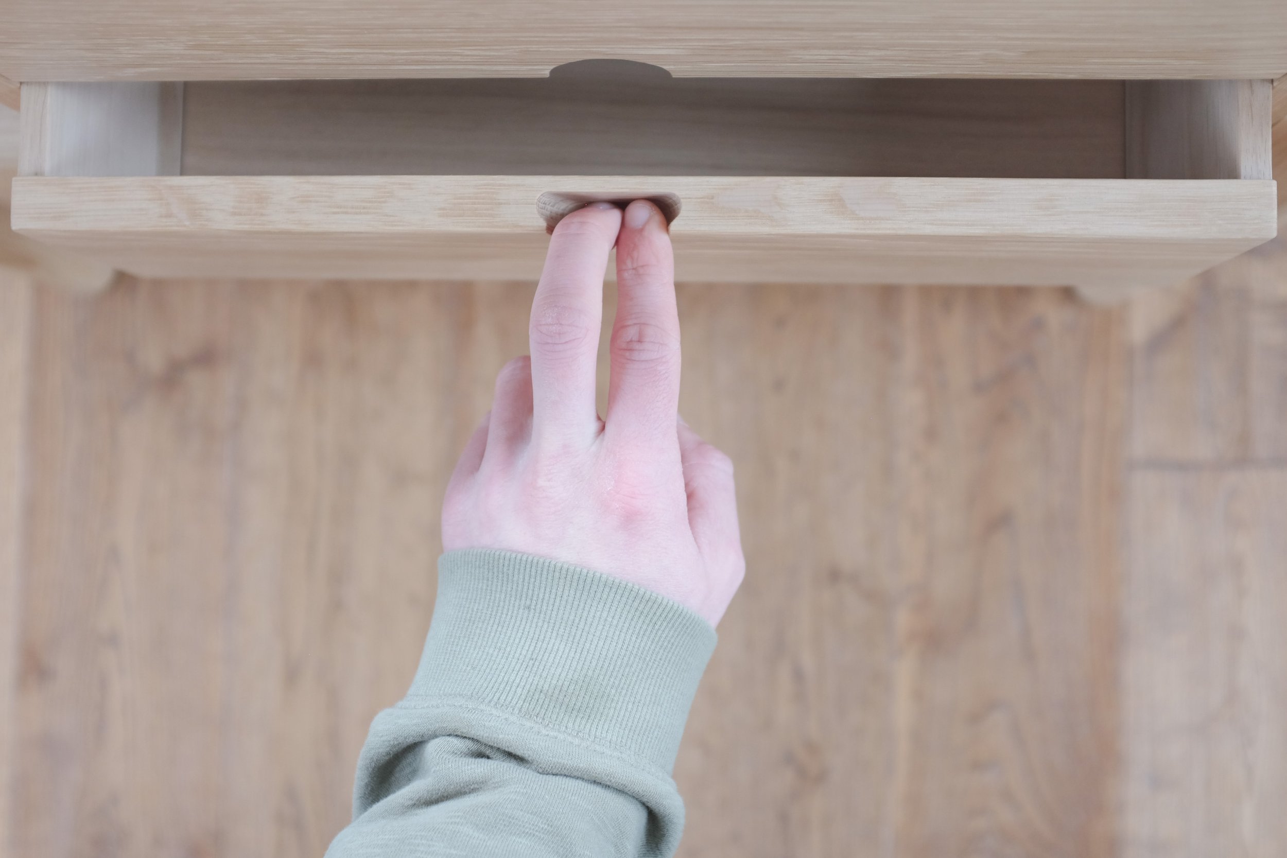 Hand opening solid oak drawers using finger pull.