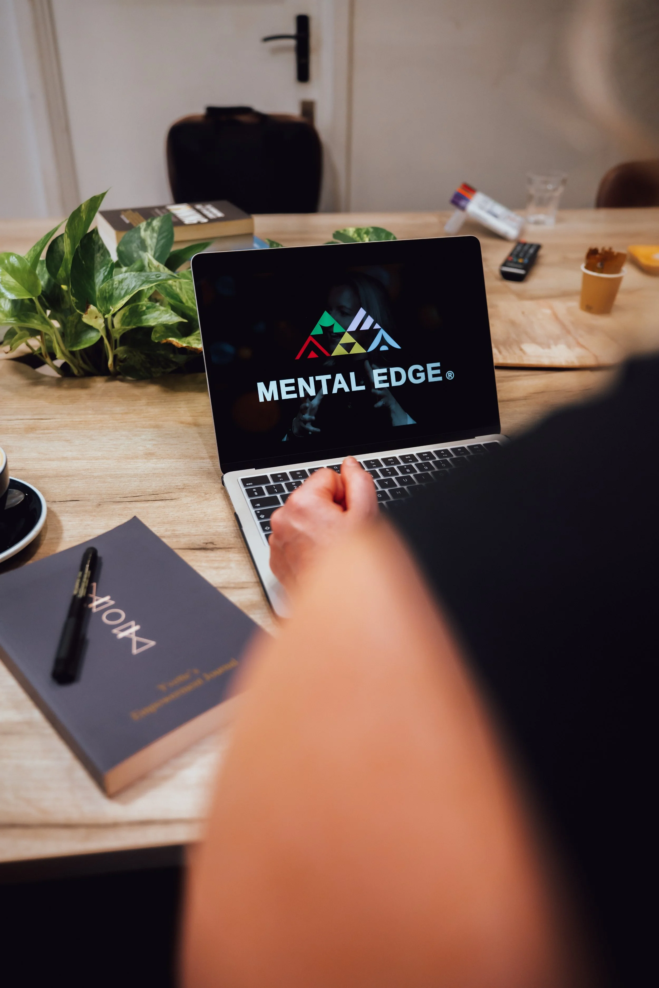 An image of a laptop with the words Mental Edge on the screen