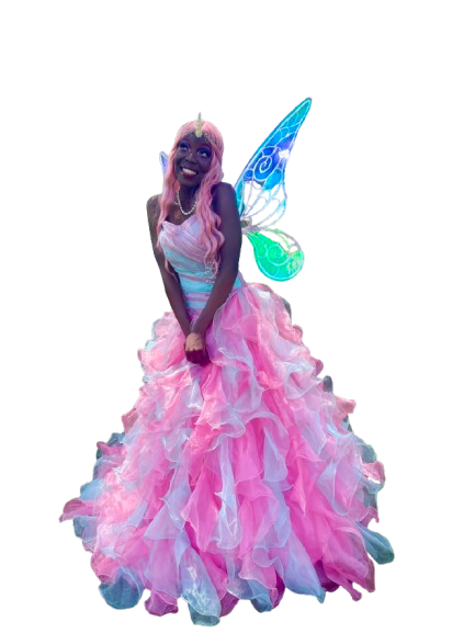 Person dressed as a fairy princess with pink hair, a pink and white dress, colorful fairy wings, and a unicorn horn, standing against a black background.