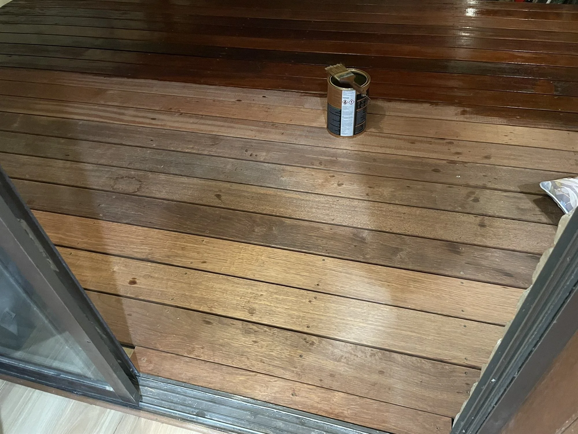 Freshly oiled timber deck landing beside a sliding door