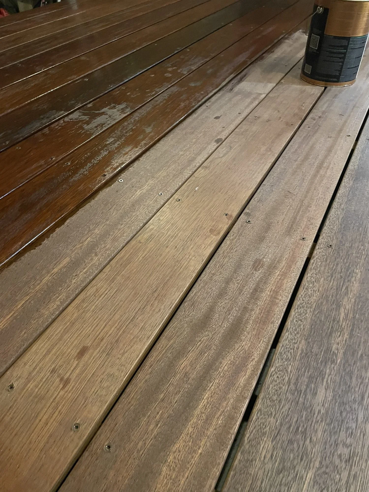 Close-up of oiled timber deck boards showing the restored natural grain