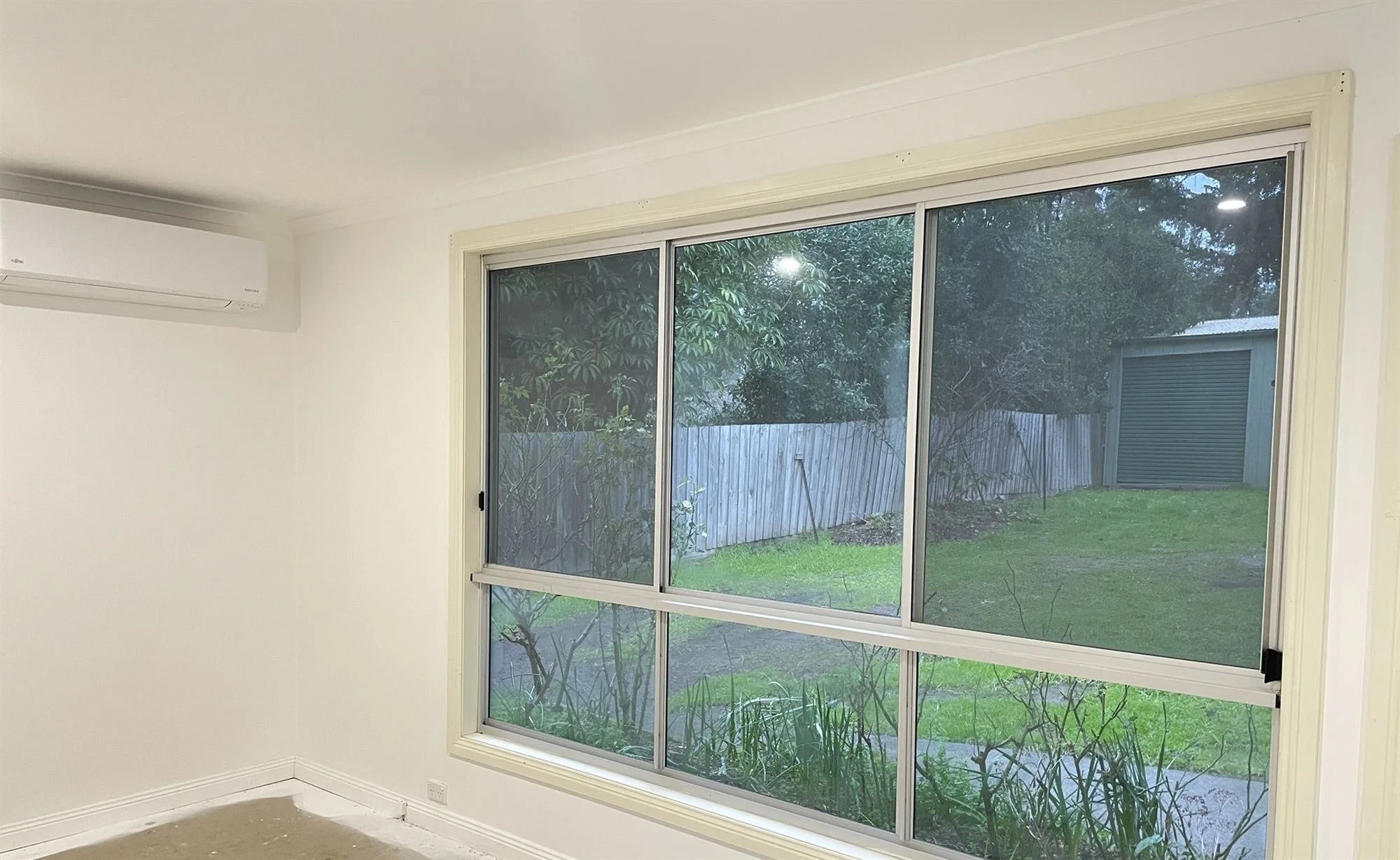 Freshly painted room in a new house extension, with a large window overlooking the garden