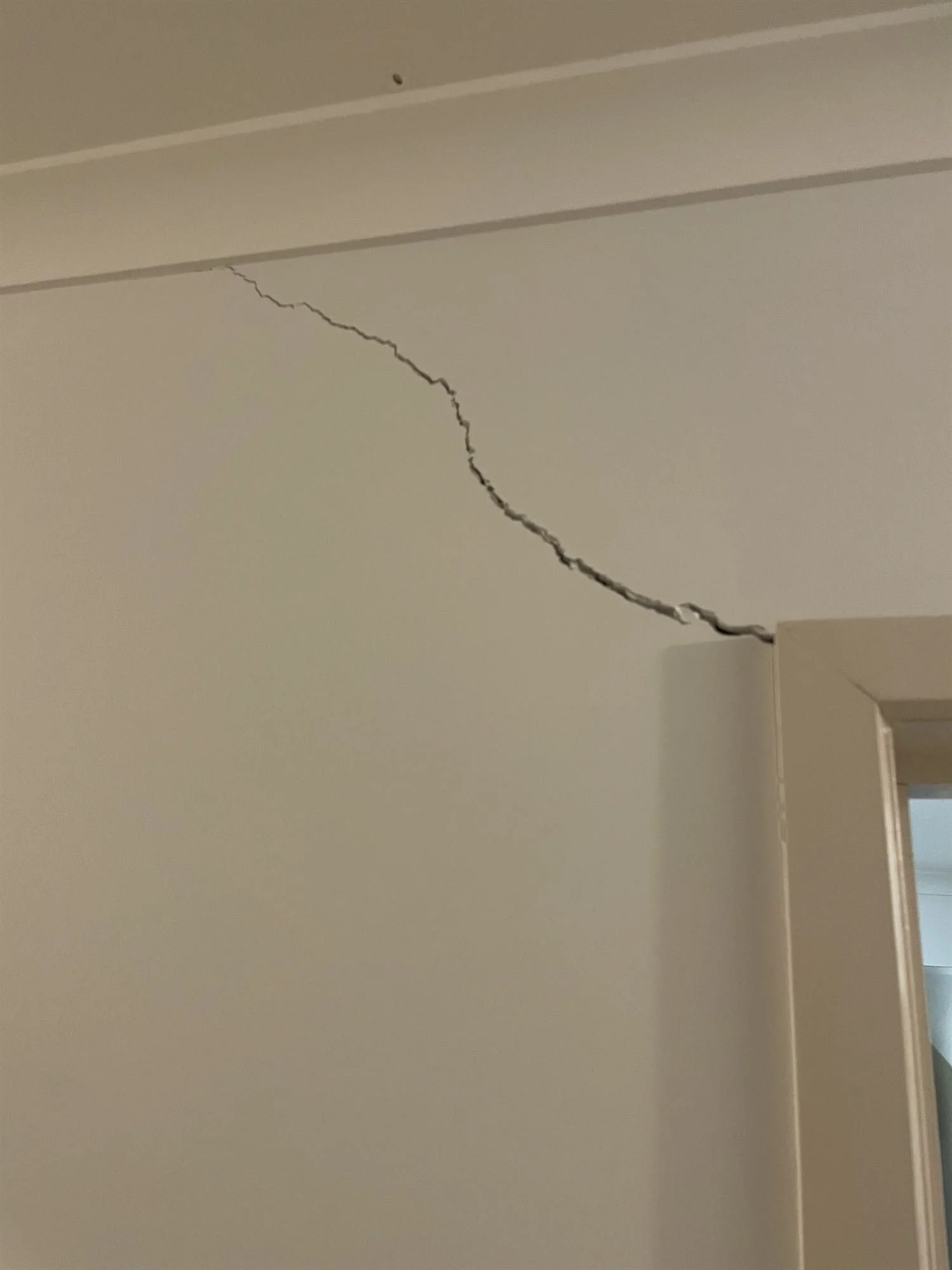 Crack in the wall below the cornice before repair and repainting