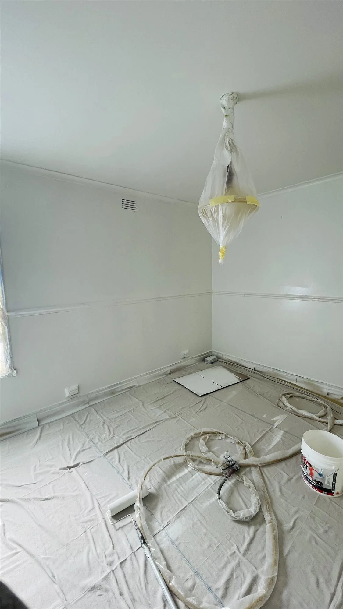 Freshly painted white room with floor protection still in place