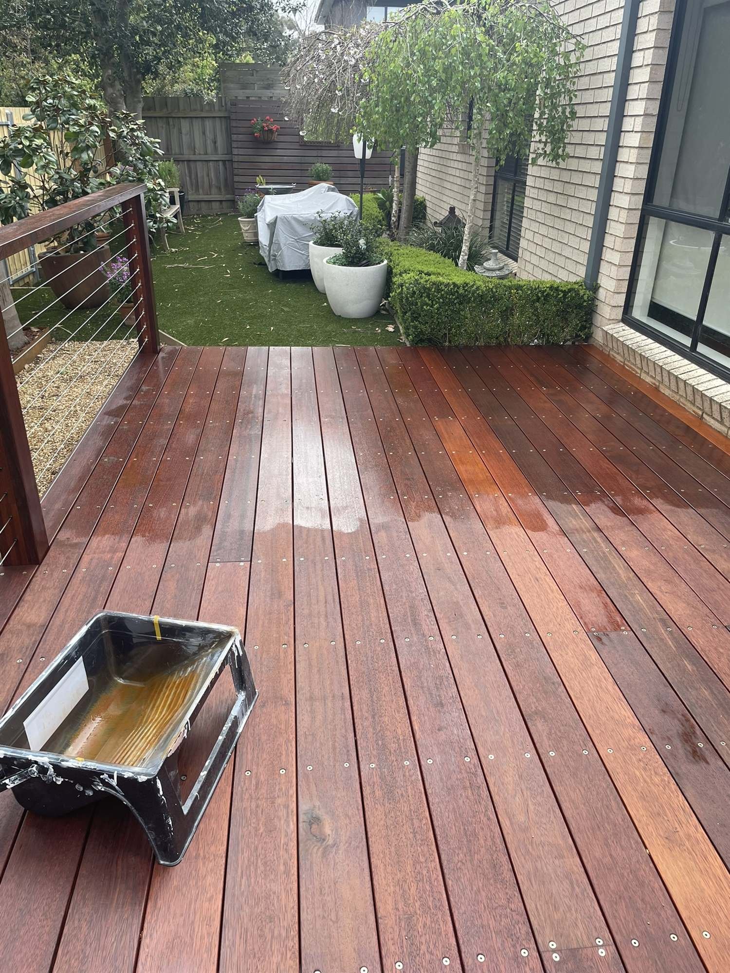 Oil tray on a new hardwood deck partway through oiling