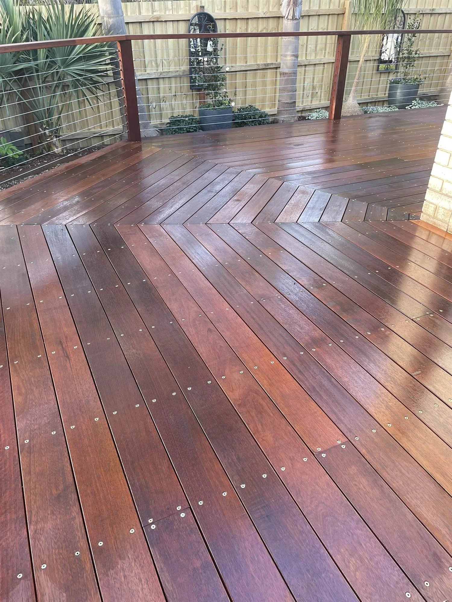 Glossy oiled hardwood deck boards laid in a chevron pattern