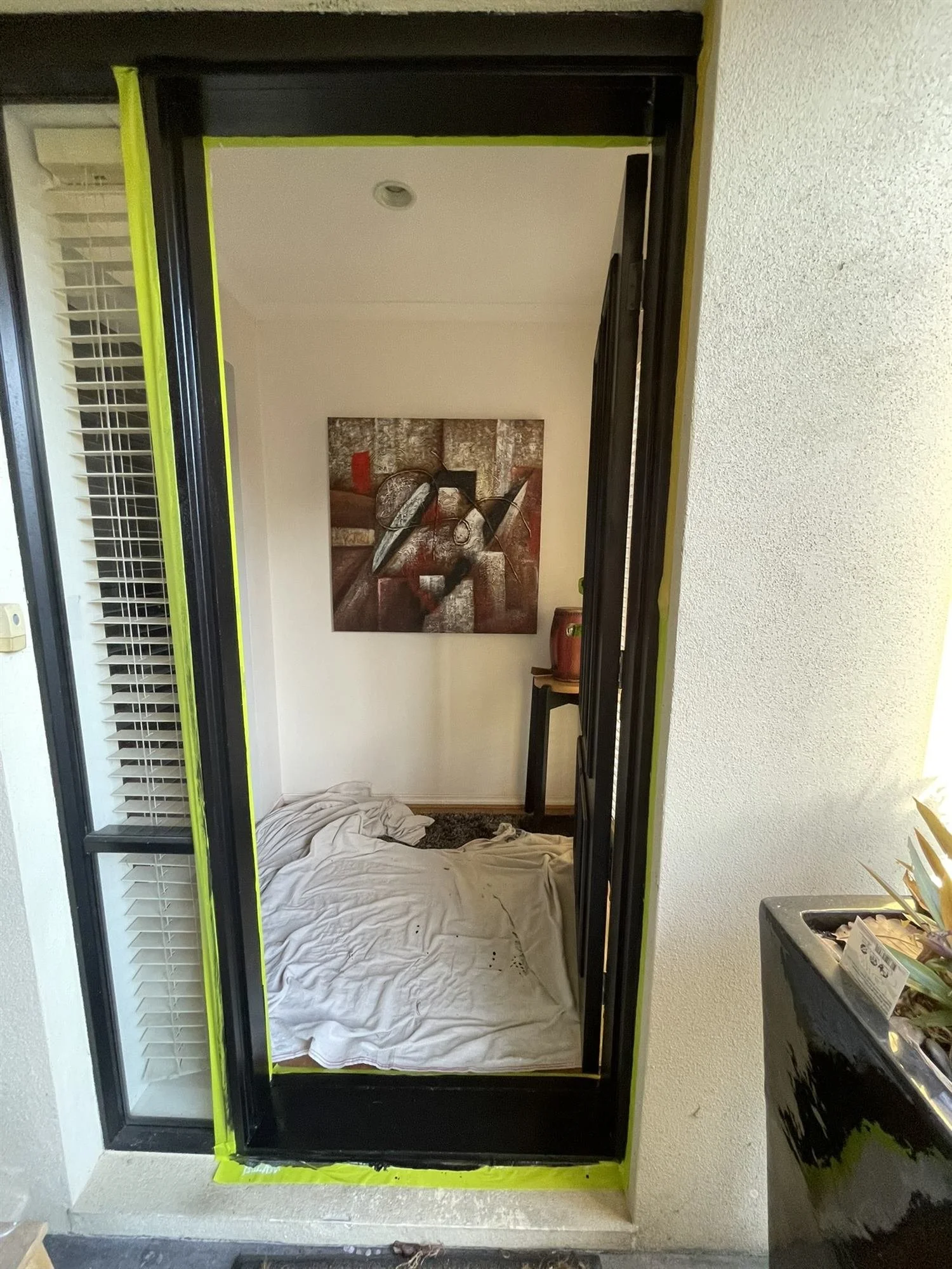 Front door frame painted black and masked, seen from outside