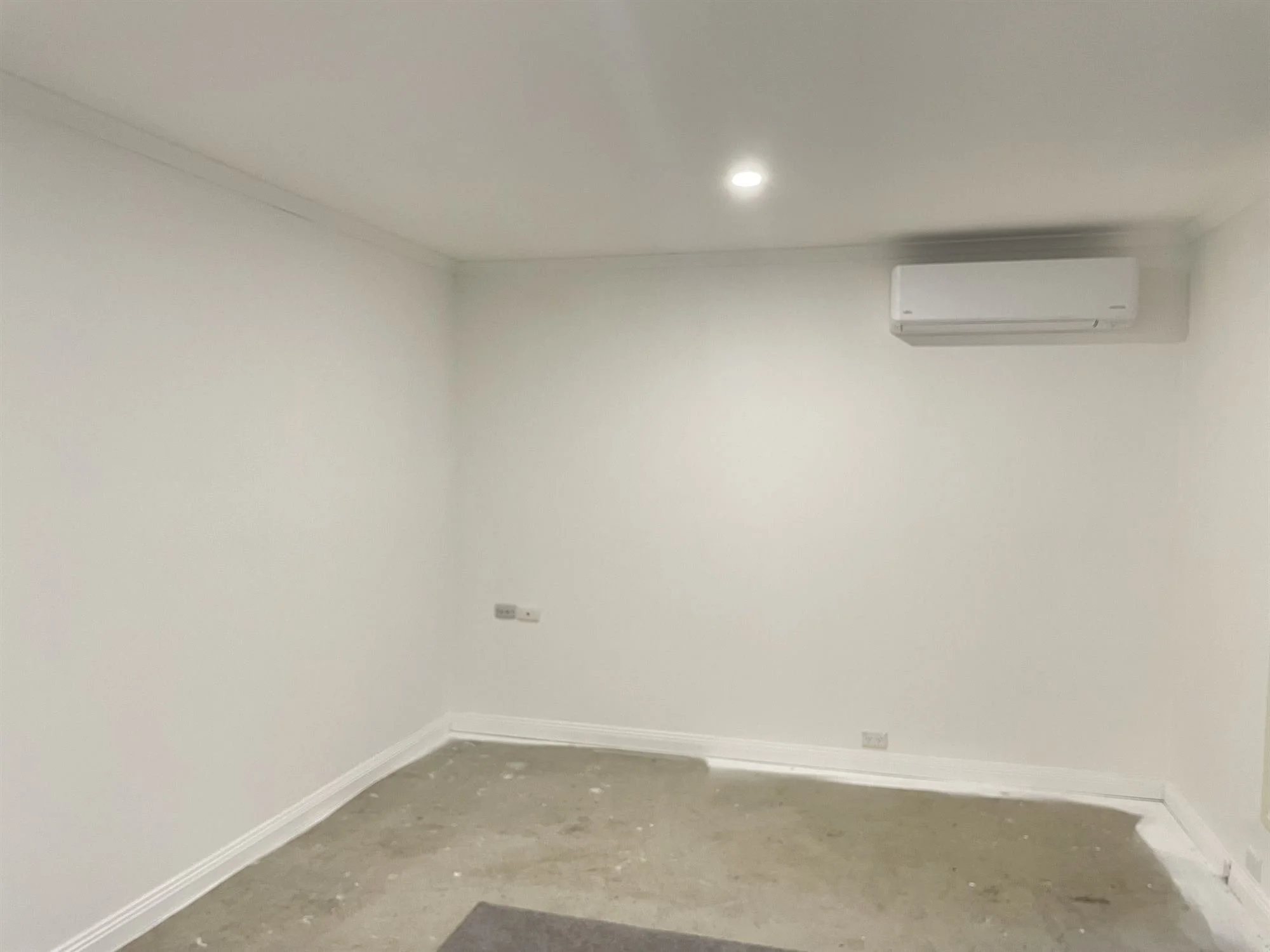 Freshly painted white room with air conditioner in a new house extension
