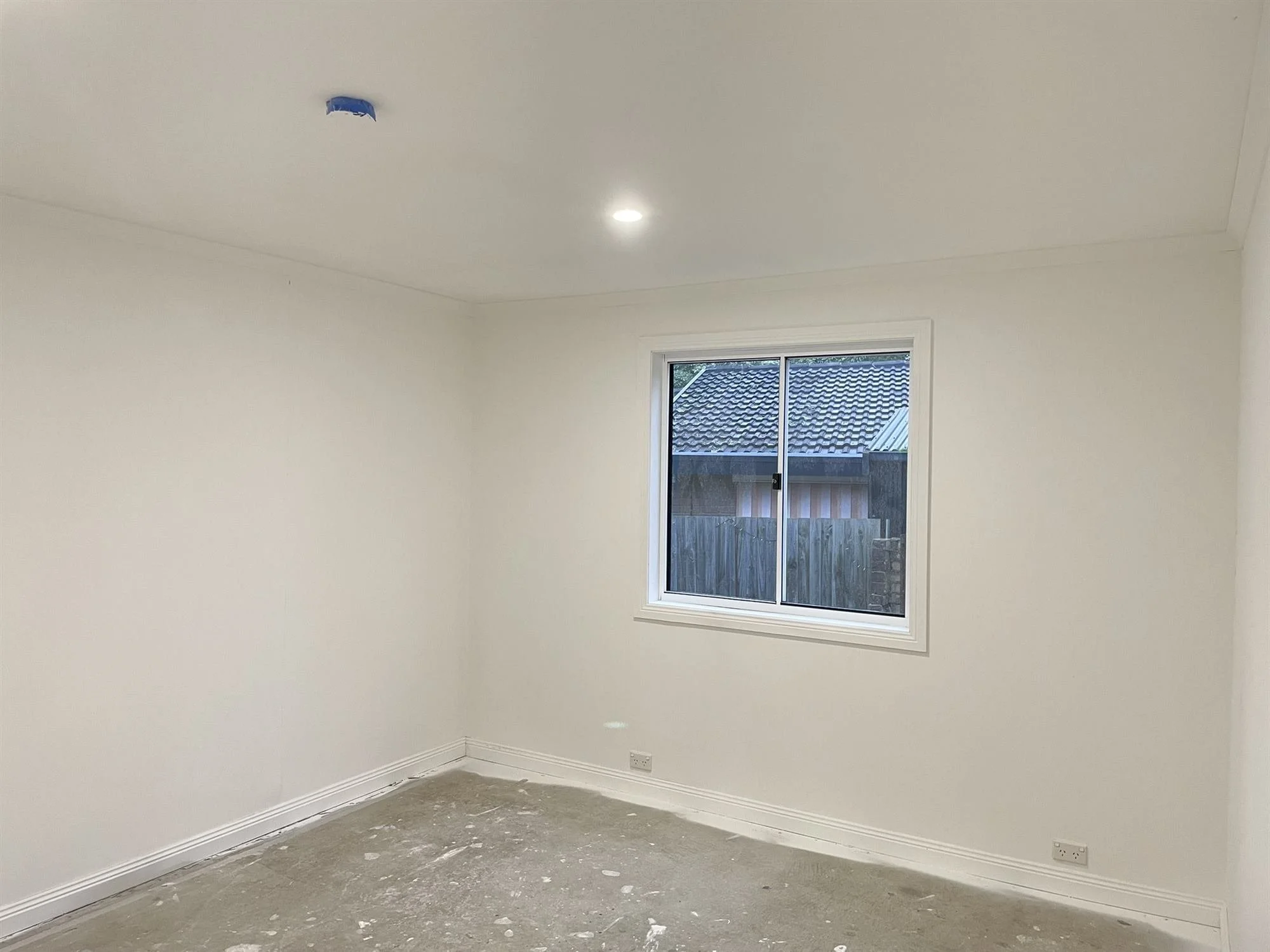 Freshly painted white room with a window in a new house extension