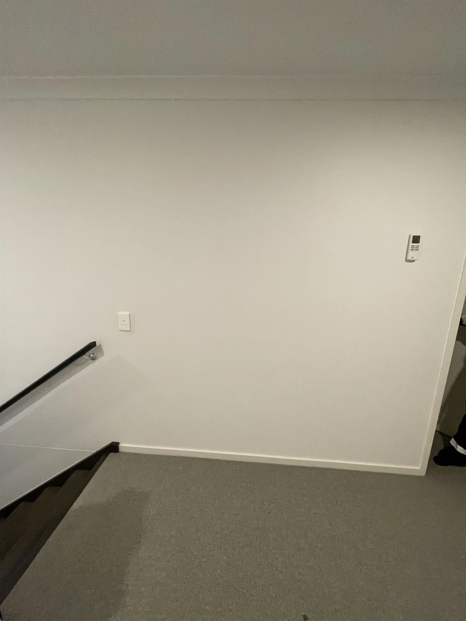 Freshly painted white landing wall at the top of a staircase