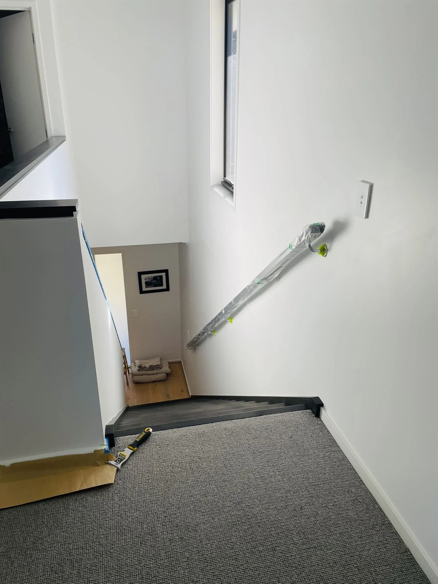Staircase handrail wrapped in plastic to protect it during wall painting
