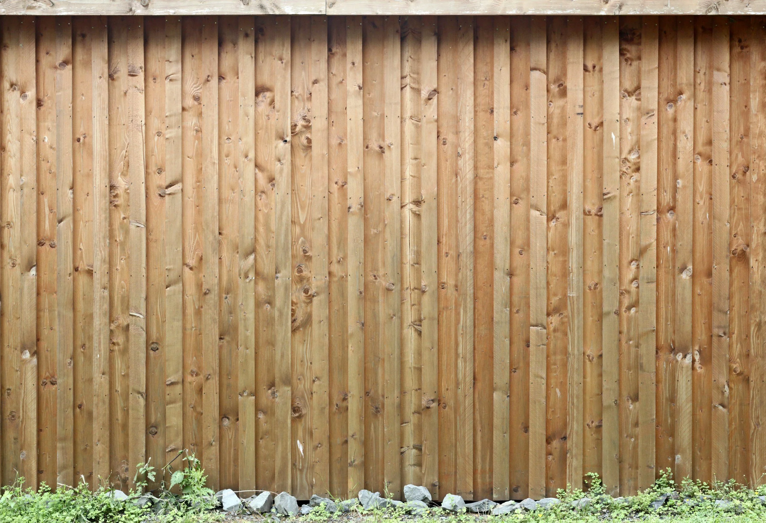 Evenly stained timber paling fence