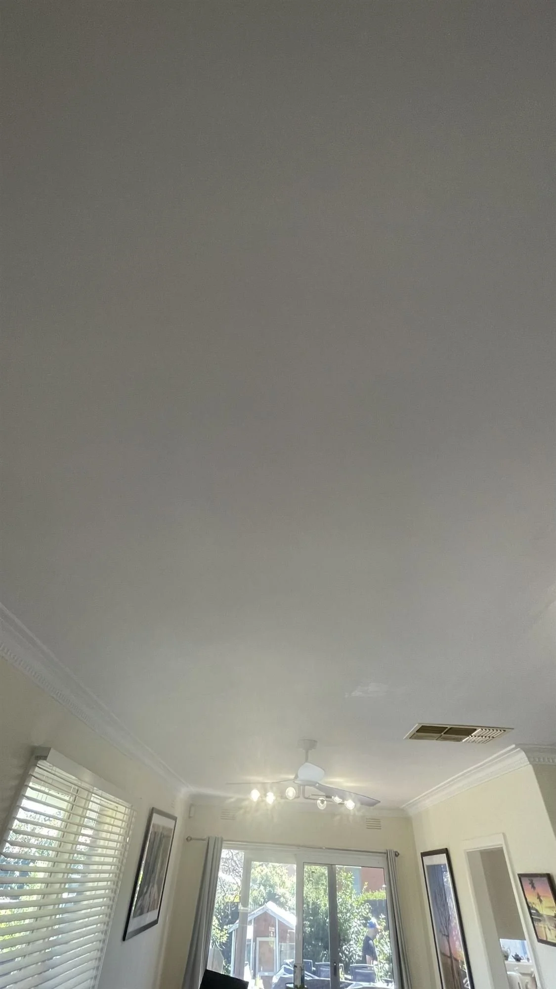 Freshly painted living room ceiling with cornice after plaster repairs
