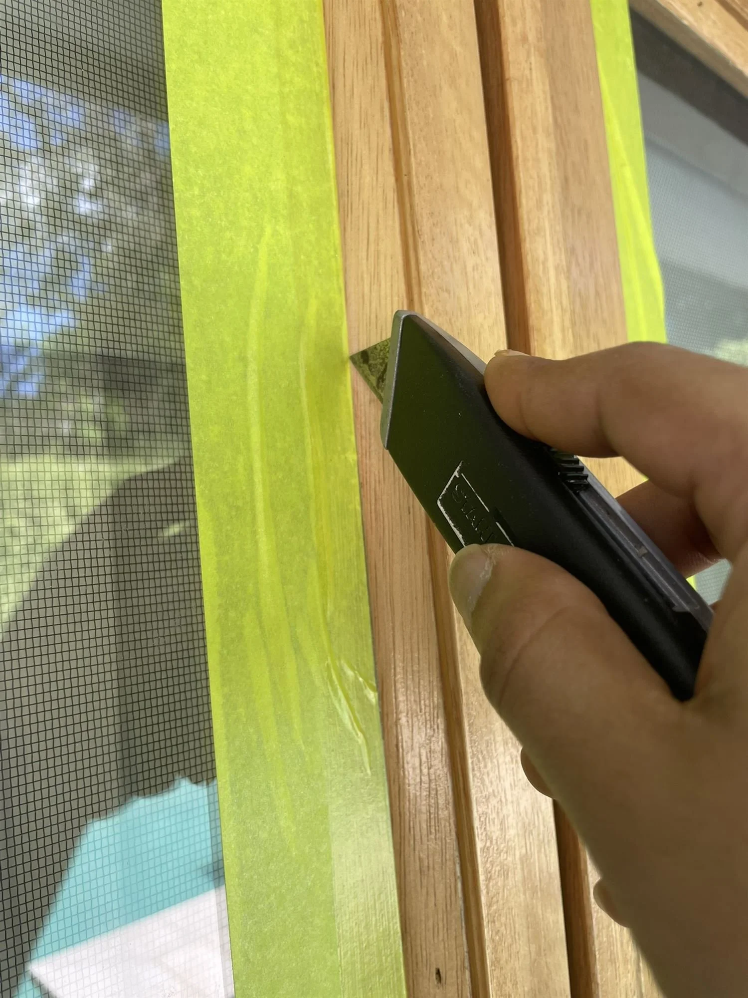 Removing masking tape from a freshly coated timber window frame